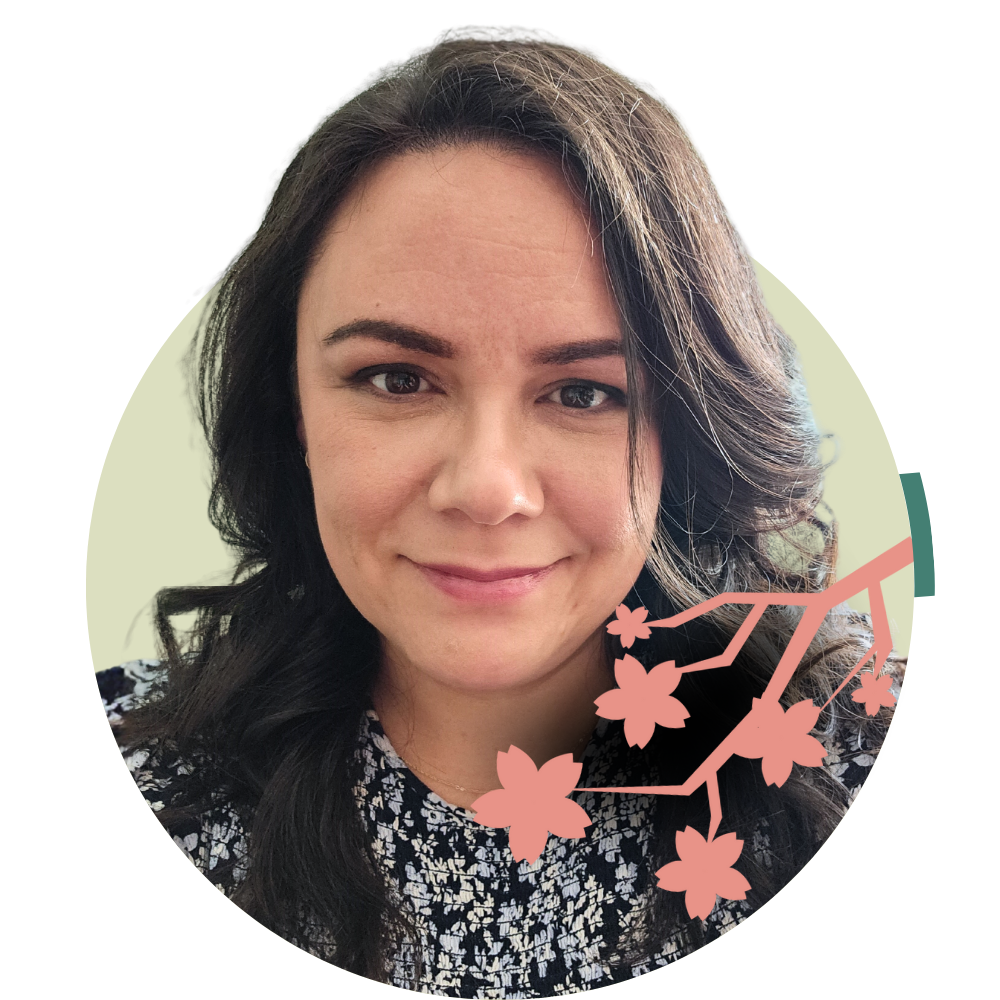 Thumbnail image of associate therapist Amy Commanda: A woman with dark hair and a floral-patterned top smiling at the camera with cherry blossom branch graphic overlay.