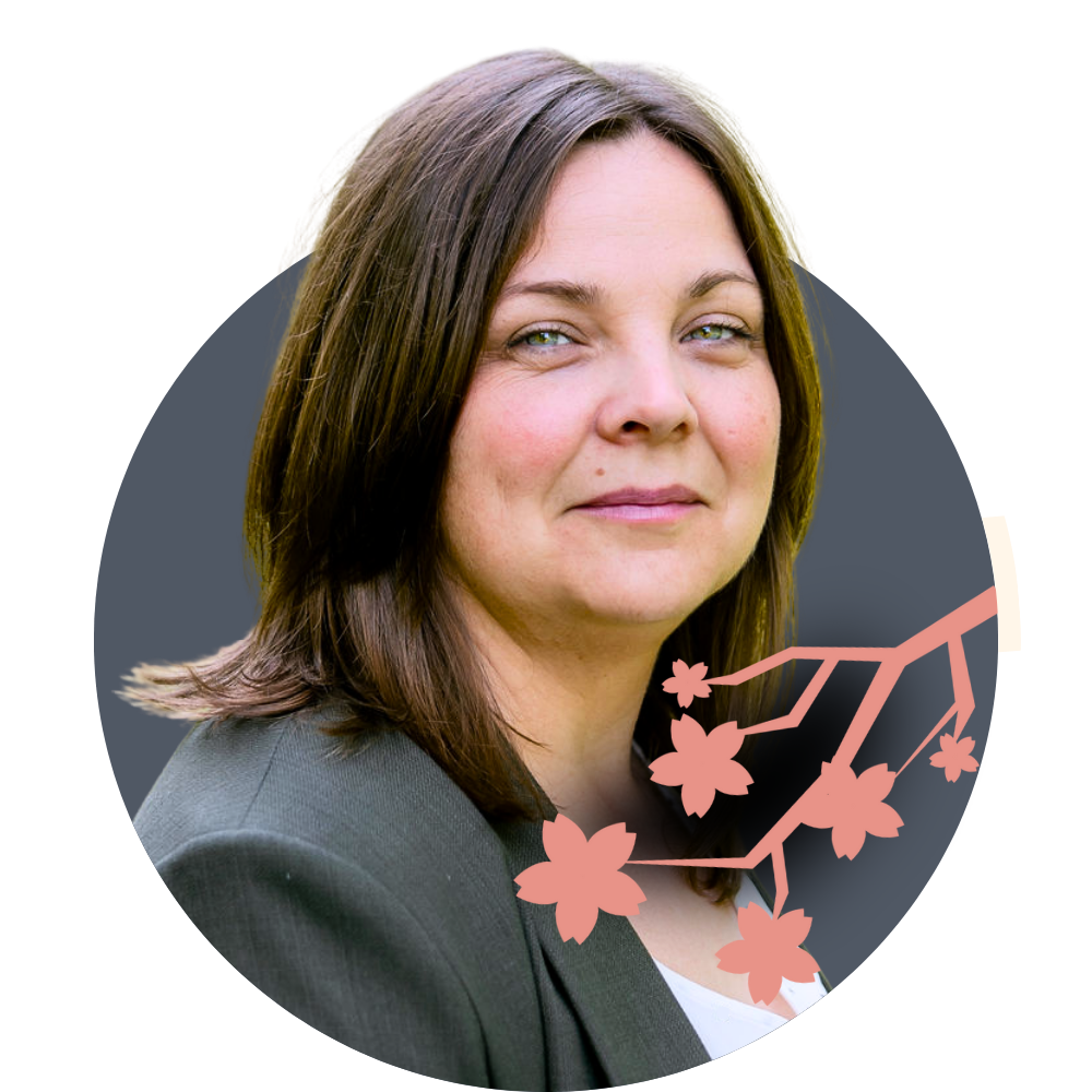 Thumbnail image of associate therapist Rebecca Harper: A woman with shoulder-length brown hair, wearing a gray blazer, looking at the camera with a slight smile. There is an illustration of a cherry blossom branch overlaid on the bottom right.