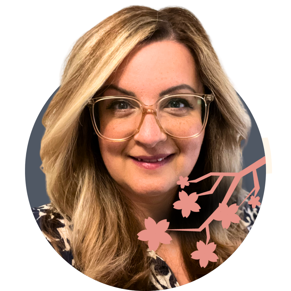 Thumbnail image of associate therapist Lauren Anastasi: A woman with long blonde hair, glasses, and a floral-patterned top smiling at the camera with a pink cherry blossom branch graphic overlay.