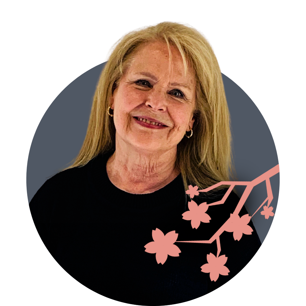 Thumbnail image of associate therapist Michelle Stockwell: A woman with long blonde hair smiling, wearing a black top and small hoop earrings, with pink cherry blossom branch illustration overlayed on the lower right side.