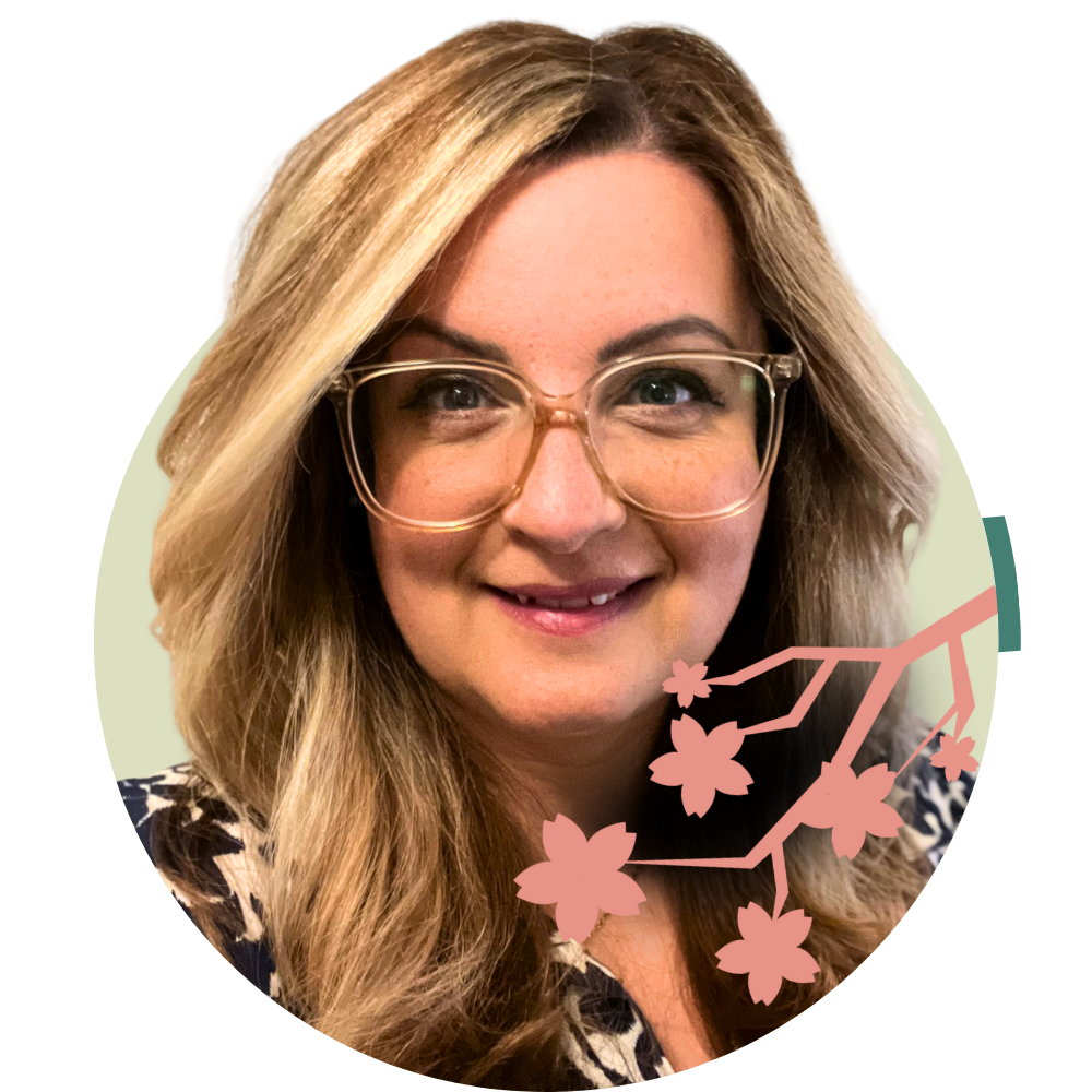 Thumbnail image of associate therapist Lauren Anastasi: A woman with blonde hair, glasses, and a floral top smiling at the camera, with an illustrated branch of pink flowers overlayed on the lower right of the image.