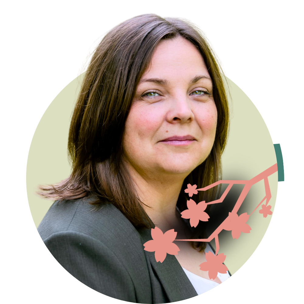 Thumbnail image of associate therapist Rebecca Harper: Portrait of a woman with shoulder-length brown hair and a confident expression, wearing a dark blazer, and a graphic illustration of cherry blossoms overlaid on the bottom right of the image.