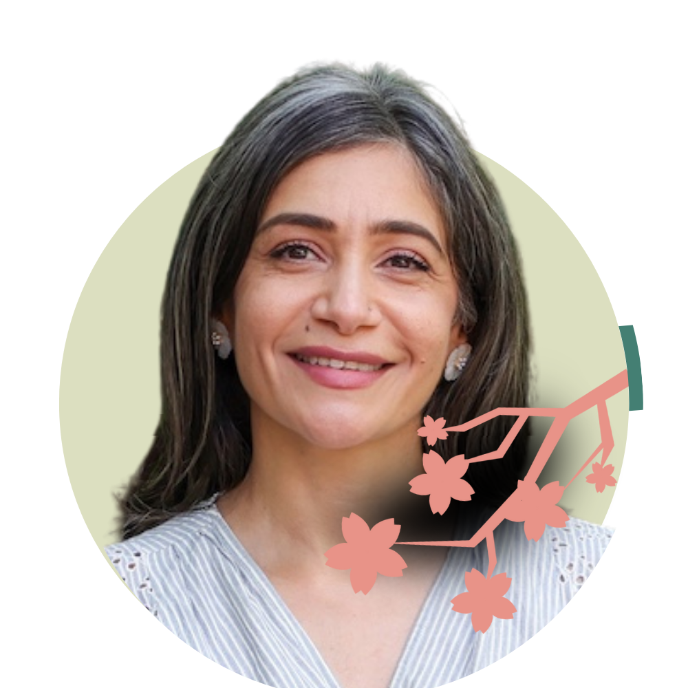 Thumbnail image of associate therapist Shabana Omar: Portrait of a smiling woman with dark hair, wearing a light-colored top and earrings, with pink illustrated cherry blossom branches overlayed.
