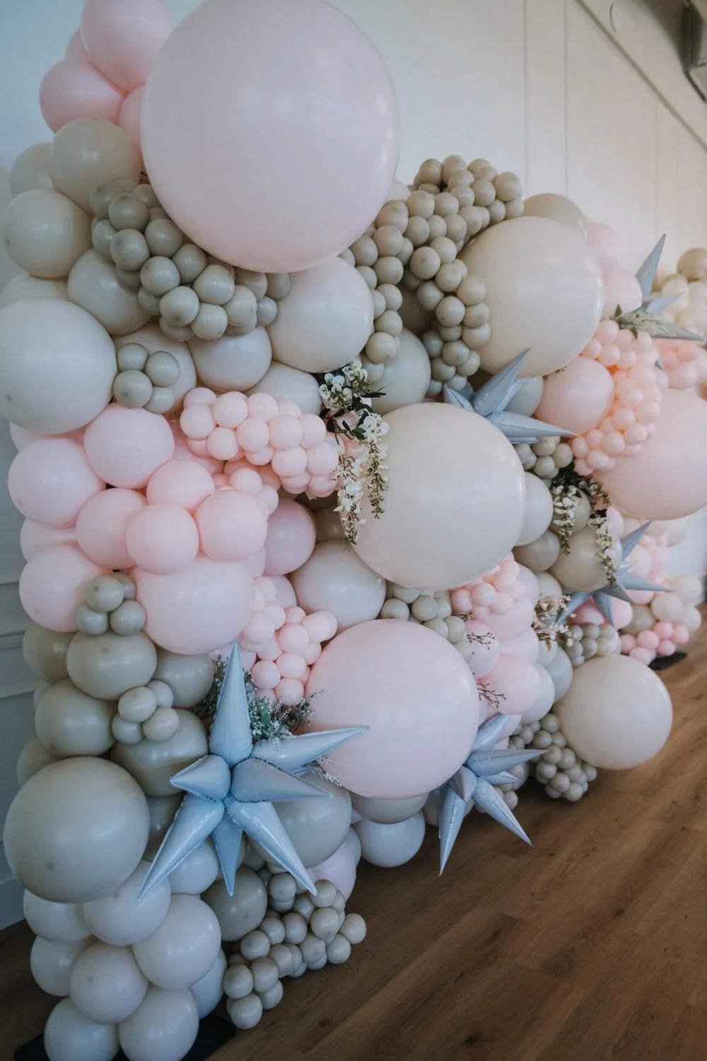 Neutral tones balloon wall with starburst balloons and faux floral accents