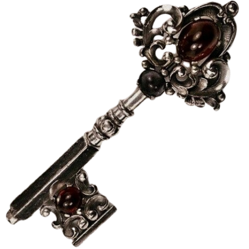An ornate, vintage-style metal key with elaborate decorative details and embedded dark red and black gemstones.