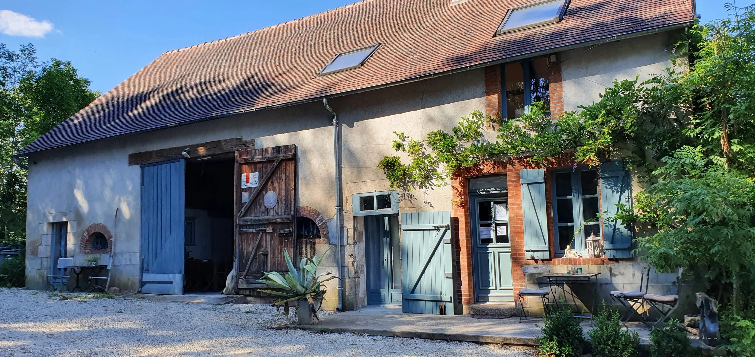 Het hoofdhuis van yogacentrum Sadhaka in Frankrijk met blauwe deuren en raamluiken waar de retraite IFS in beweging van Jeannine de Klerk plaatsvindt.