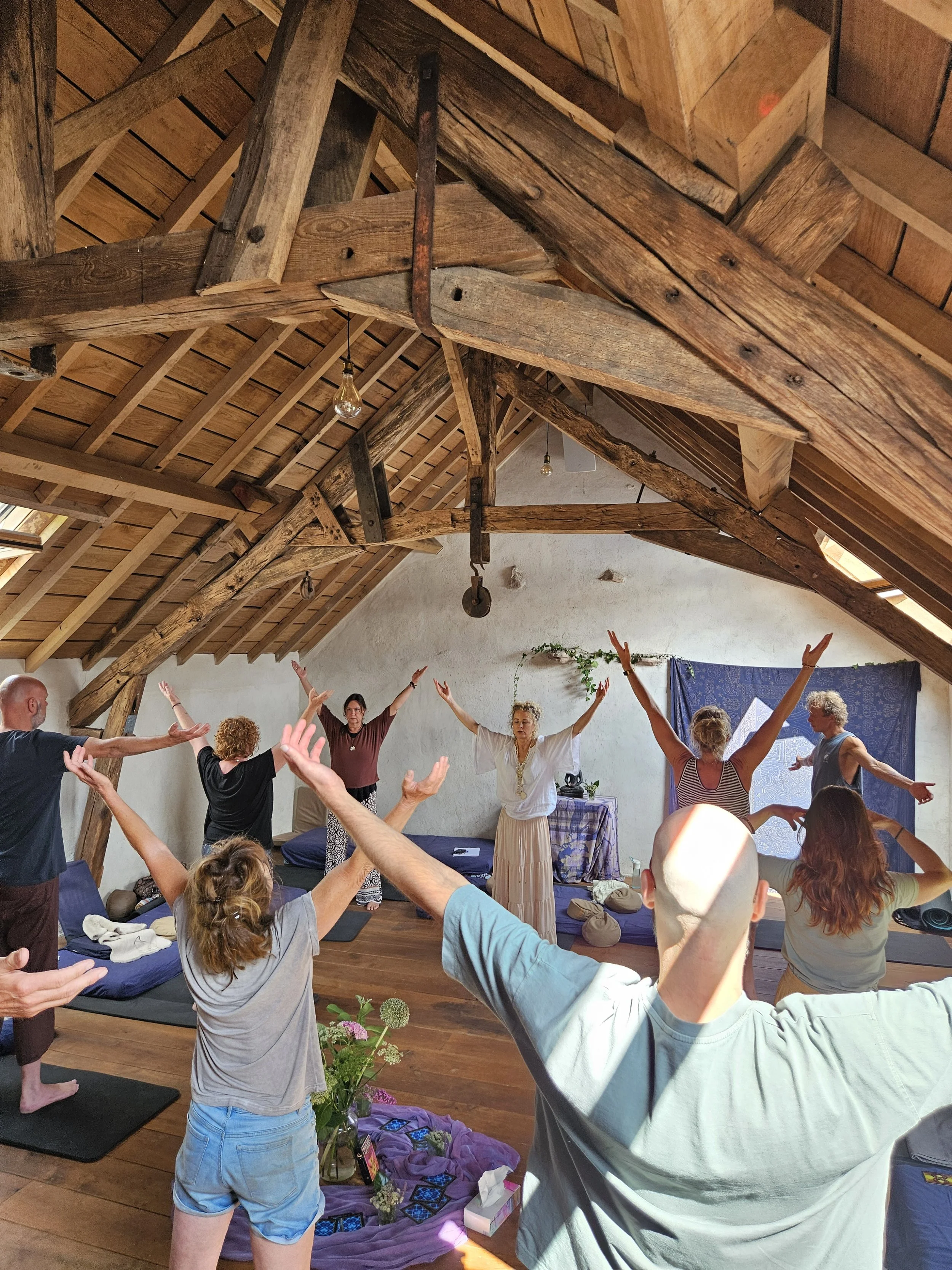 Groep mensen die deelnemen aan de retraite Internal Family Systems, yoga en meditatie in een zolderkamer met houten plafond en balken in Frankrijk, Sadhaka 