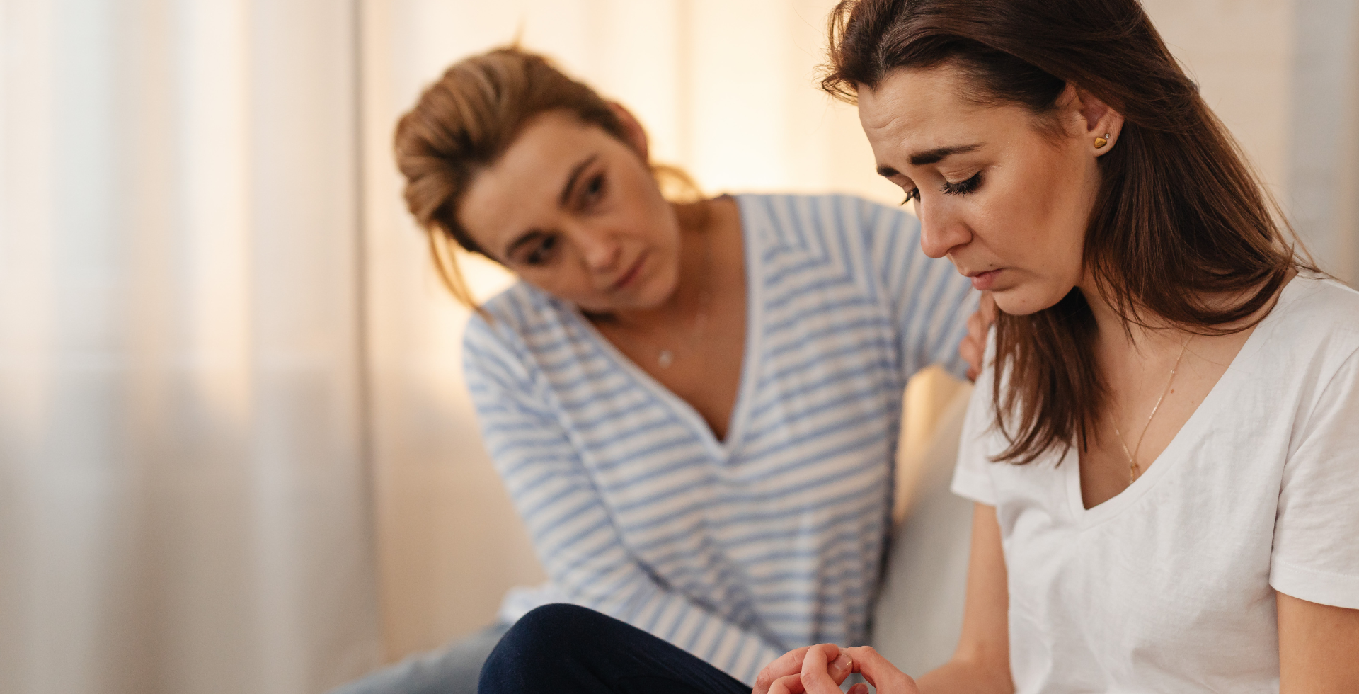 Woman offering support to another woman who is grieving