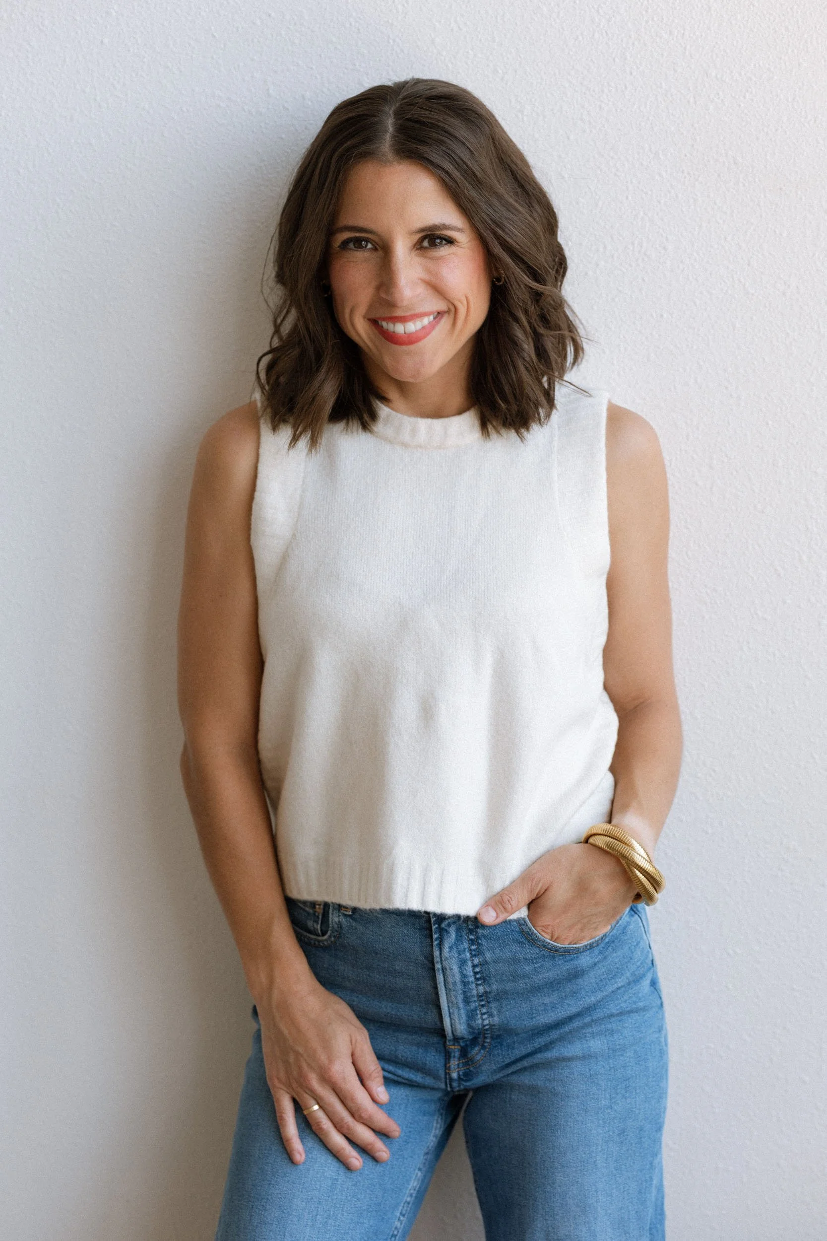 Megan Hopkins, principal copywriter at Merit & State branding agency, smiling in a cream sweater top.