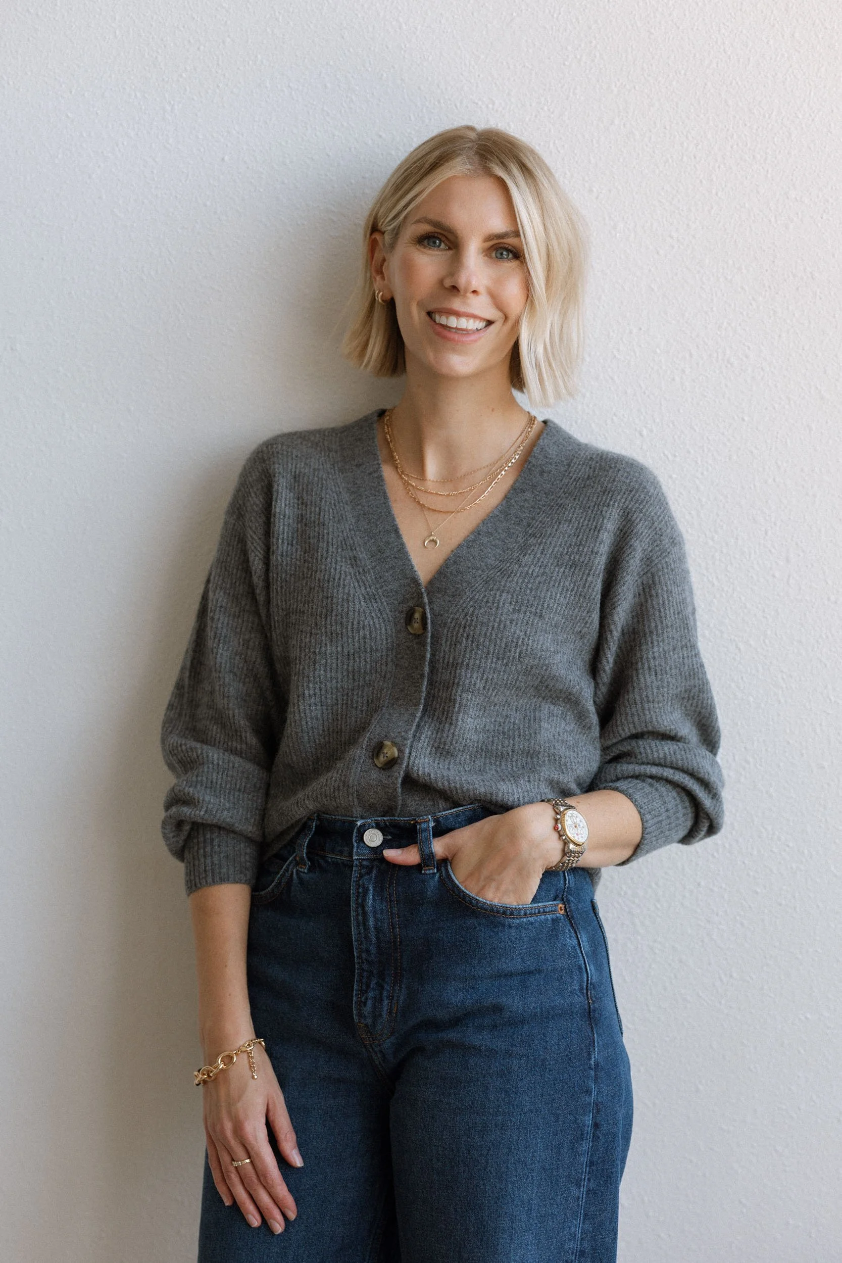 Sara Beukema, principal designer at Merit & State branding agency, smiling in a grey cardigan sweater.