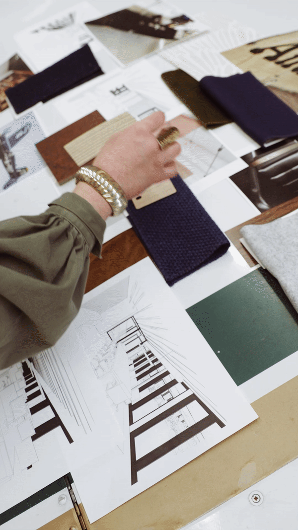 Two sets of hands are pictured working on an architecture and interior design project, sketching ideas and reviewing colors and images.