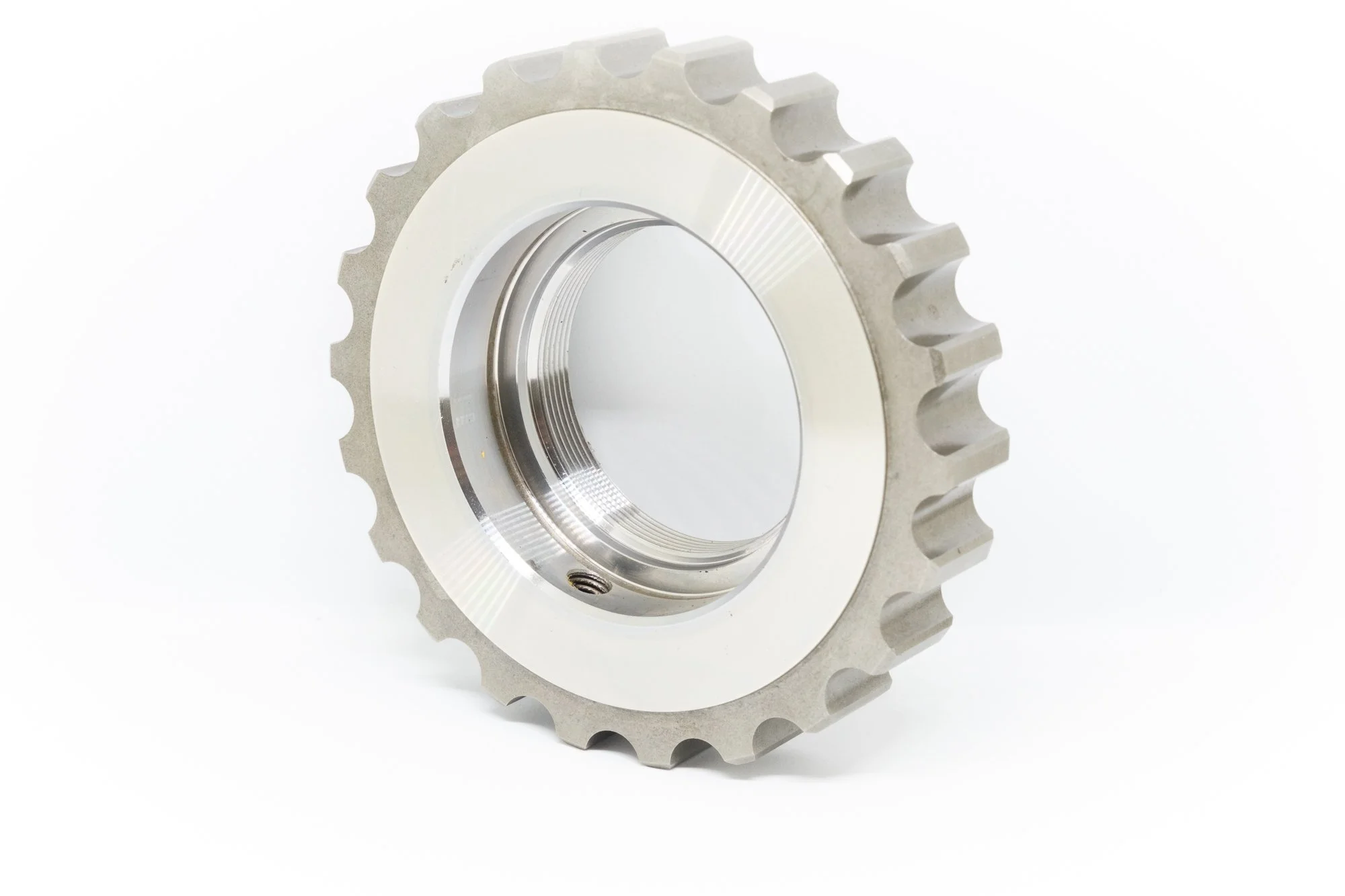 A metal gear with evenly spaced teeth, viewed at an angle against a white background.