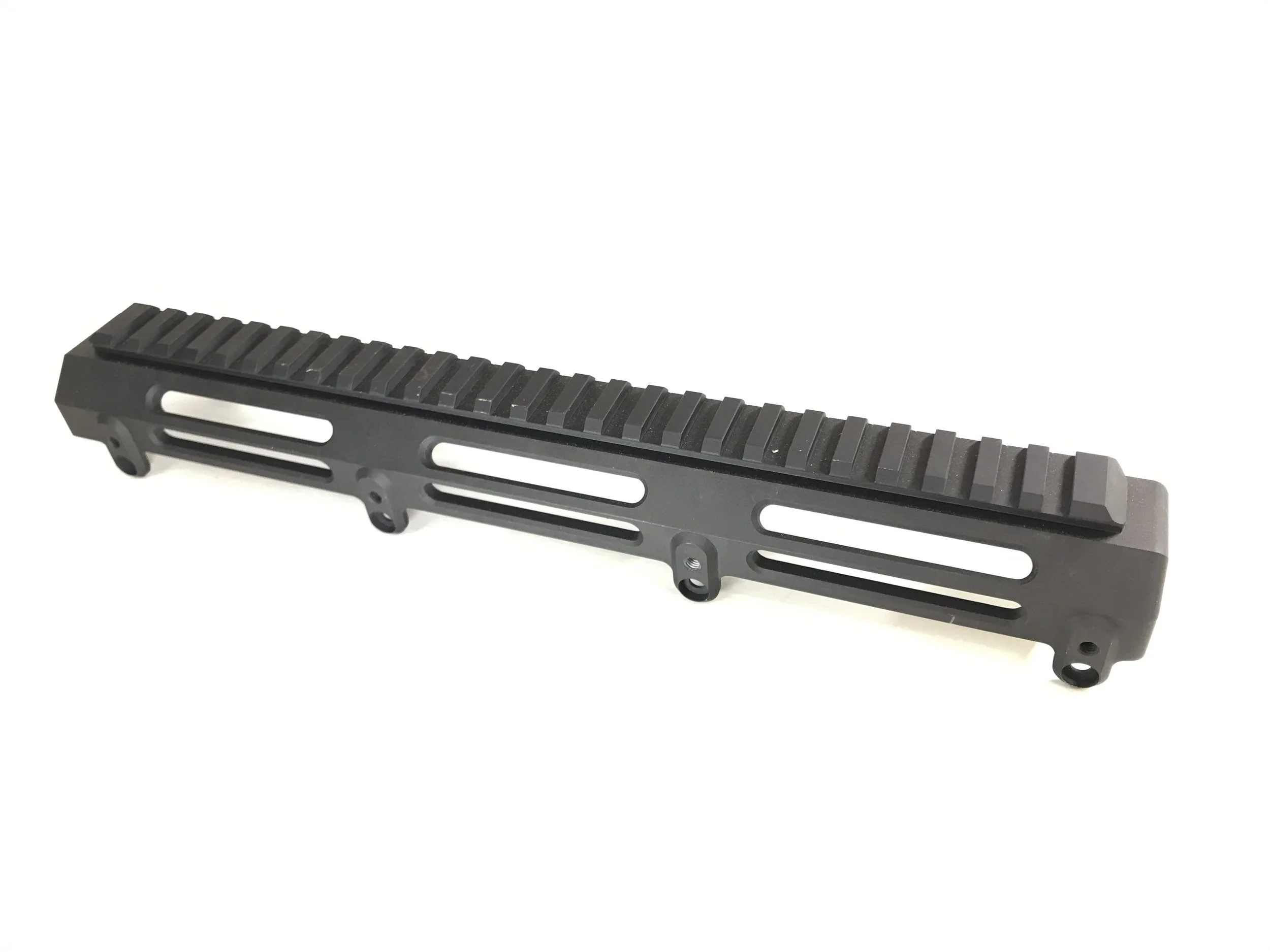 A black metal gun rail with a Picatinny-style mounting system, designed for attaching accessories to firearms.