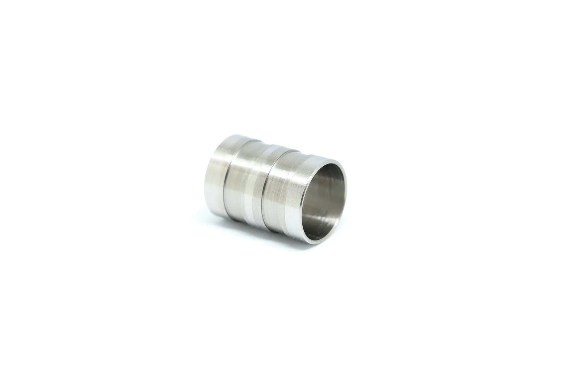 A small, metallic, cylindrical object with three segments stacked on each other, placed on a white background.