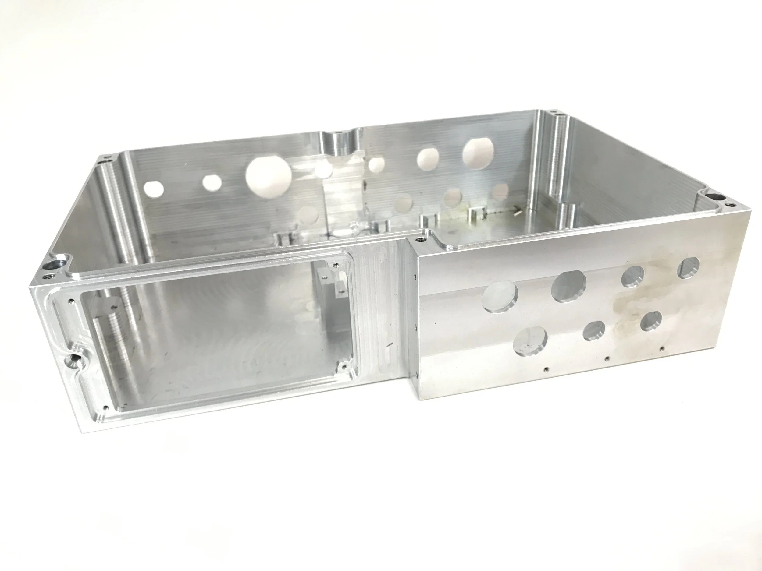 Metal rectangular enclosure with multiple circular and elongated holes, likely used in electronics or machinery.
