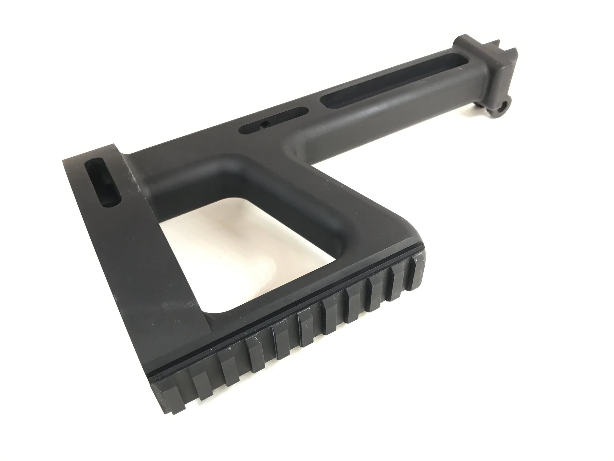 A black plastic ergonomic handle with a textured grip and a rectangular opening, possibly a tool or part for a mechanical device.