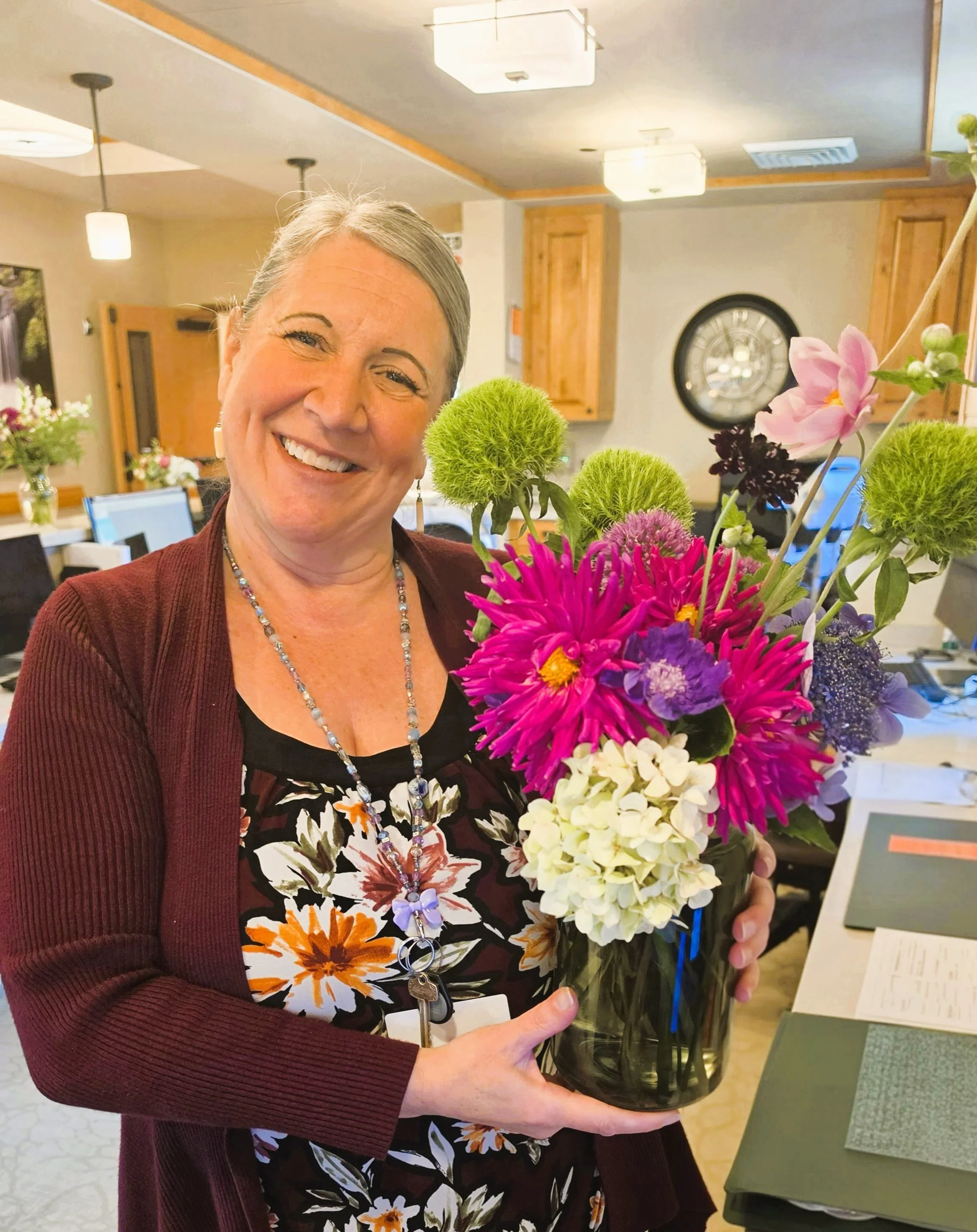 The flowers family members and friends share with loved ones at Pete Moore Hospice House are nothing short of stunning. (That&rsquo;s unit clerk Nicki showing off one of the lovely bouquets.) We love bringing a beautiful, bright piece of summer indoo