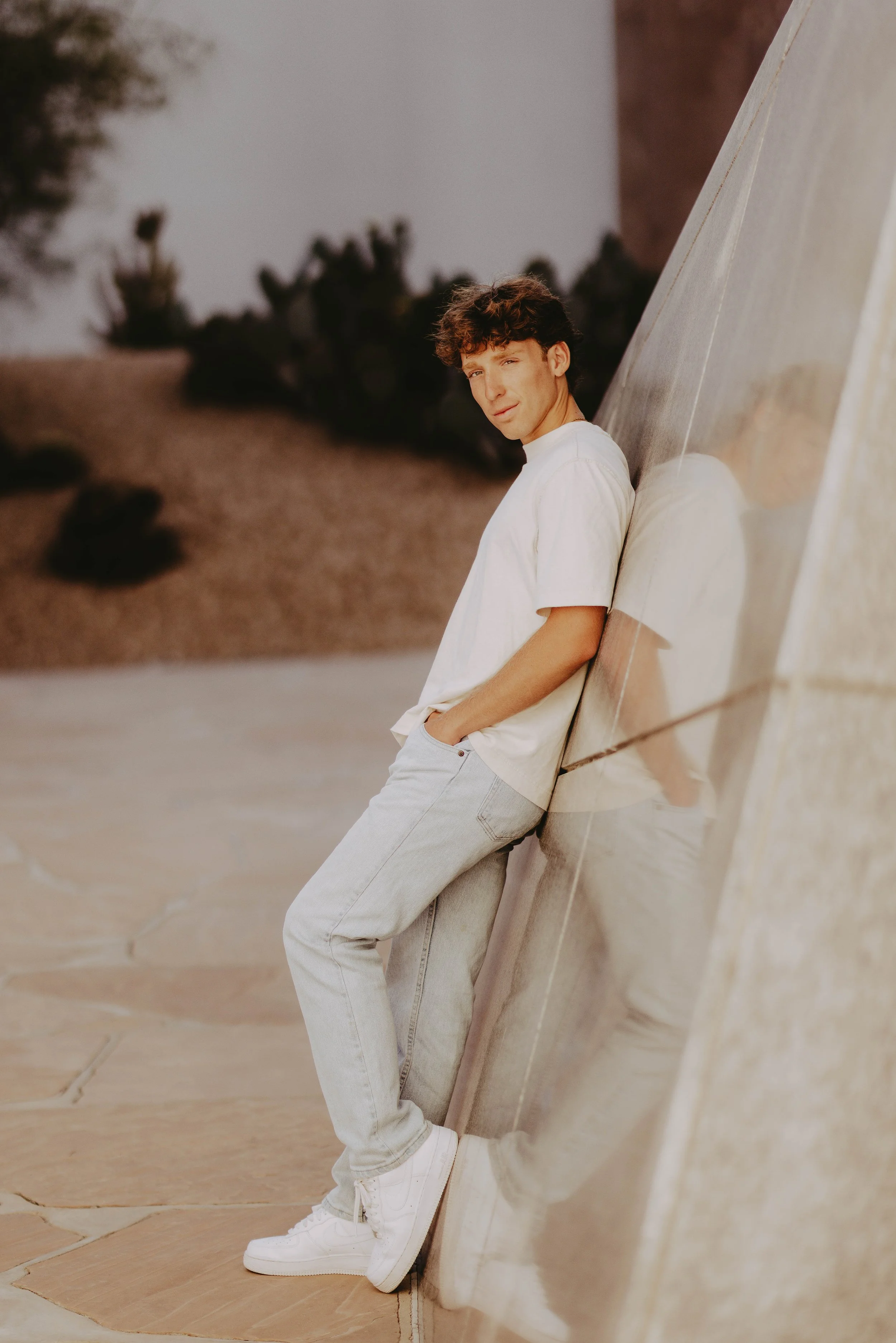  leaning senior boy poses 