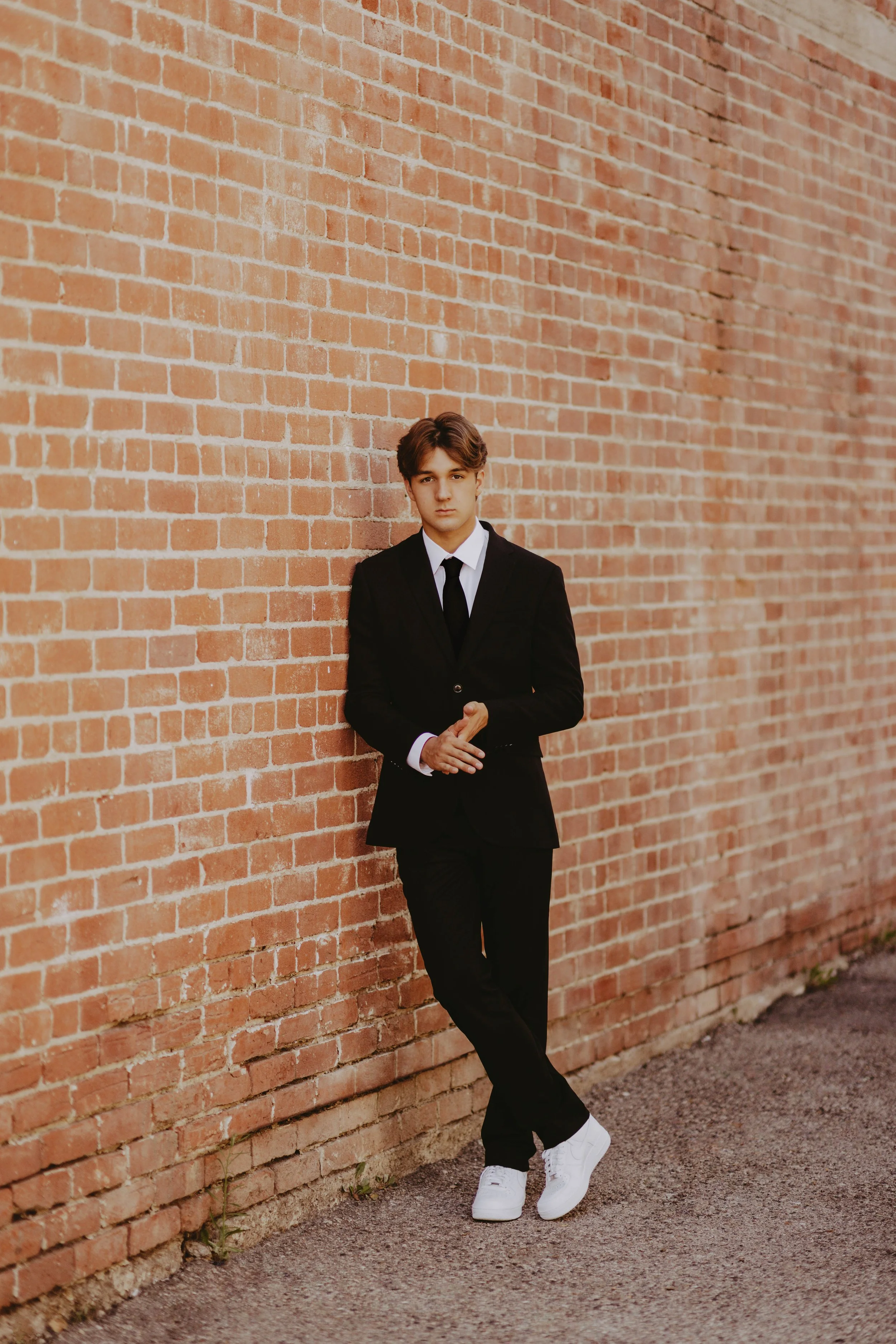  leaning senior boy poses 