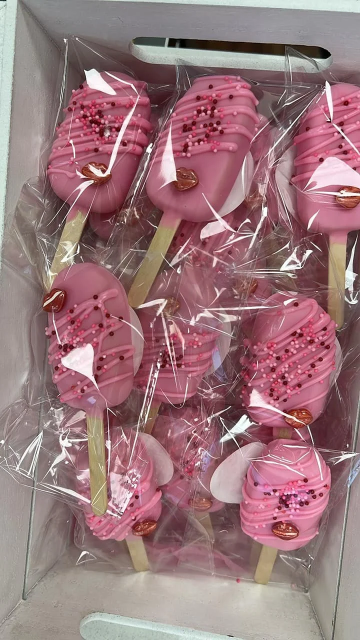 Pink Cakesicles decorated with colorful sprinkles 