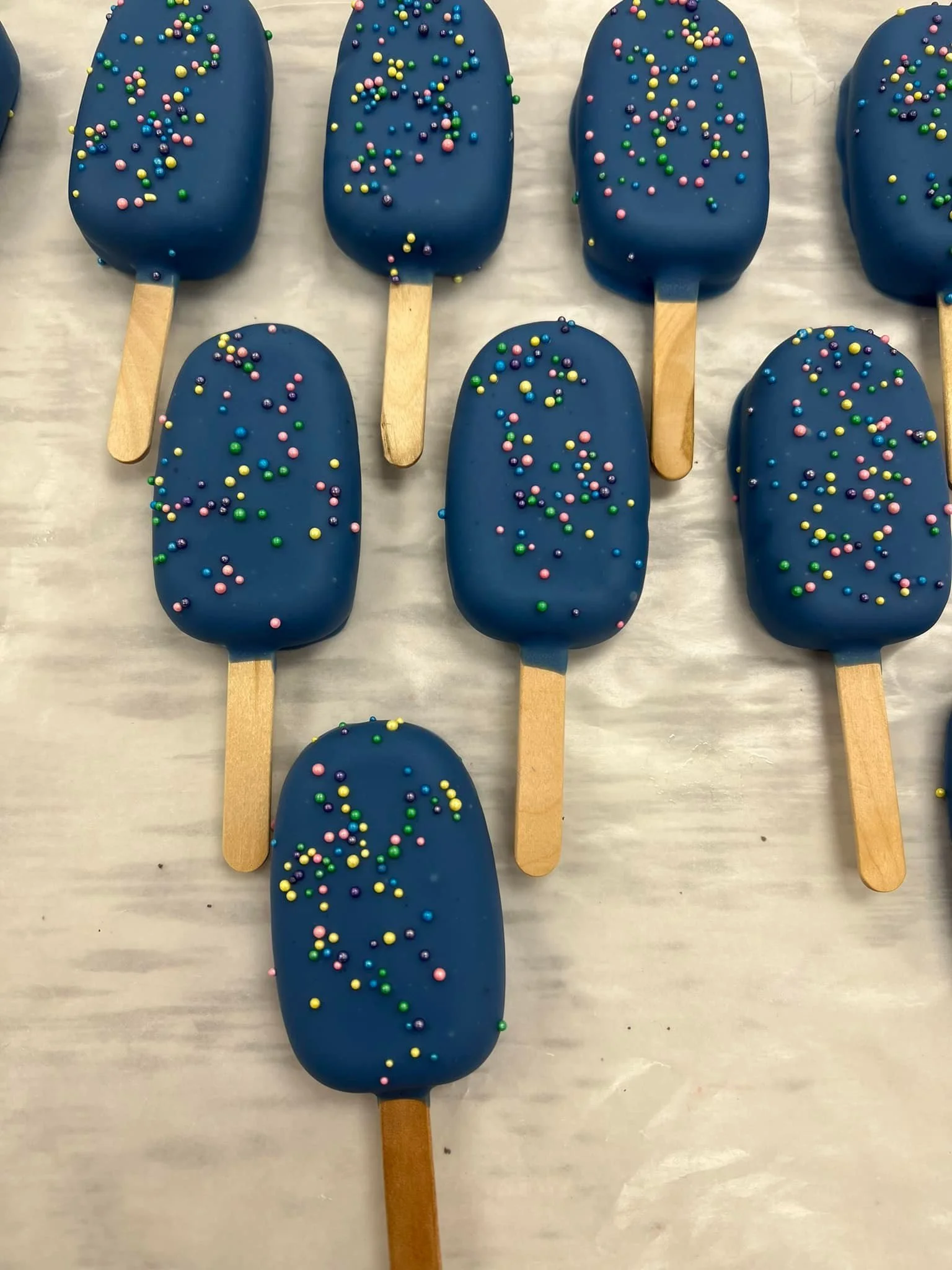Blue Cakesicles with colorful sprinkles