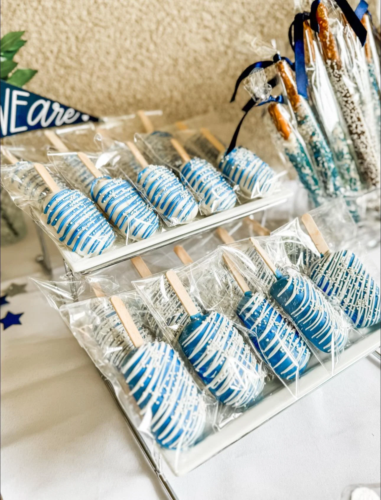 Blue and white striped and drizzled Cakesicles individually wrapped