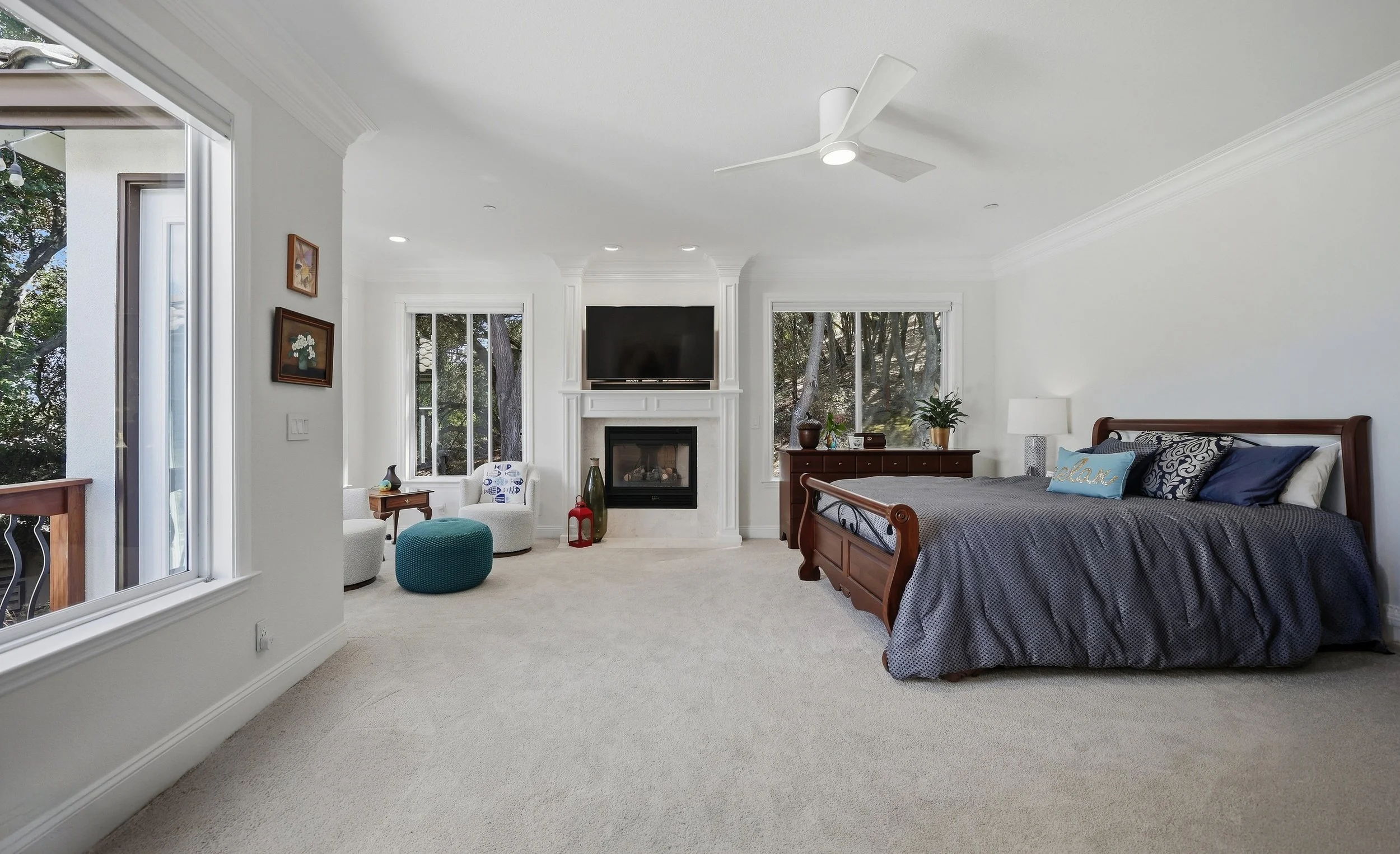 Spacious bedroom with bed, television, and a seating area.