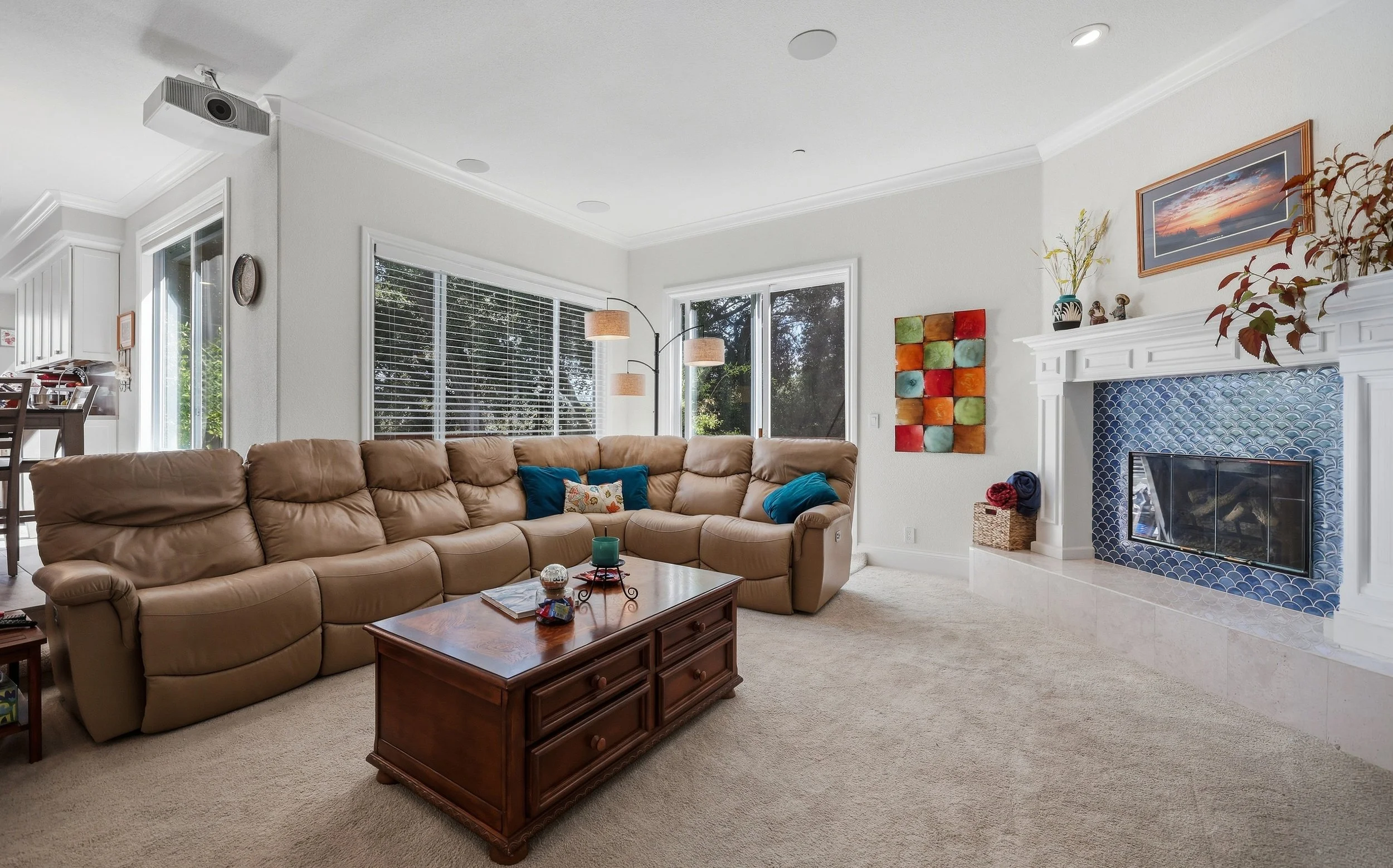 Family room with sectional sofa, coffee table, and large windows.