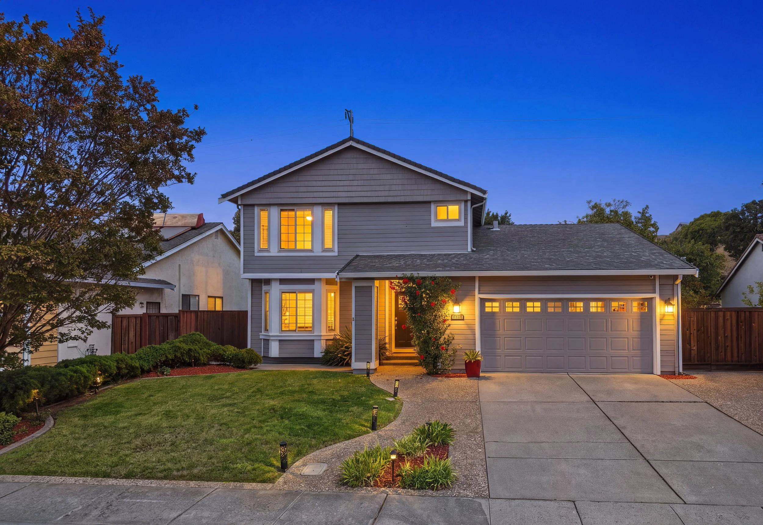 Hercules home at twilight with warm windows and illuminated front entrance.