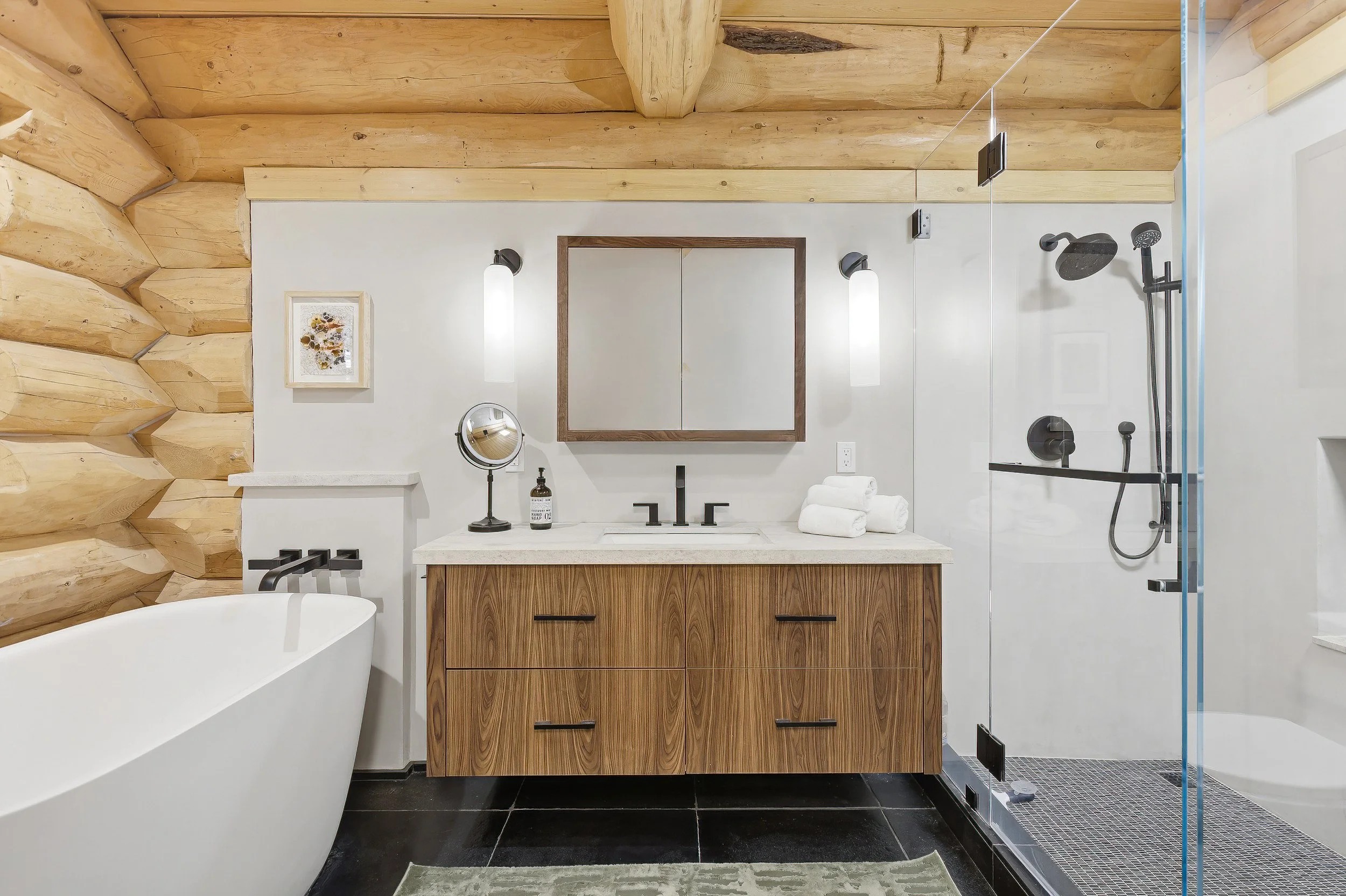 Modern bathroom with wood accents, white walls, a vanity with a mirror, a bathtub, and a walk-in shower with a glass door.