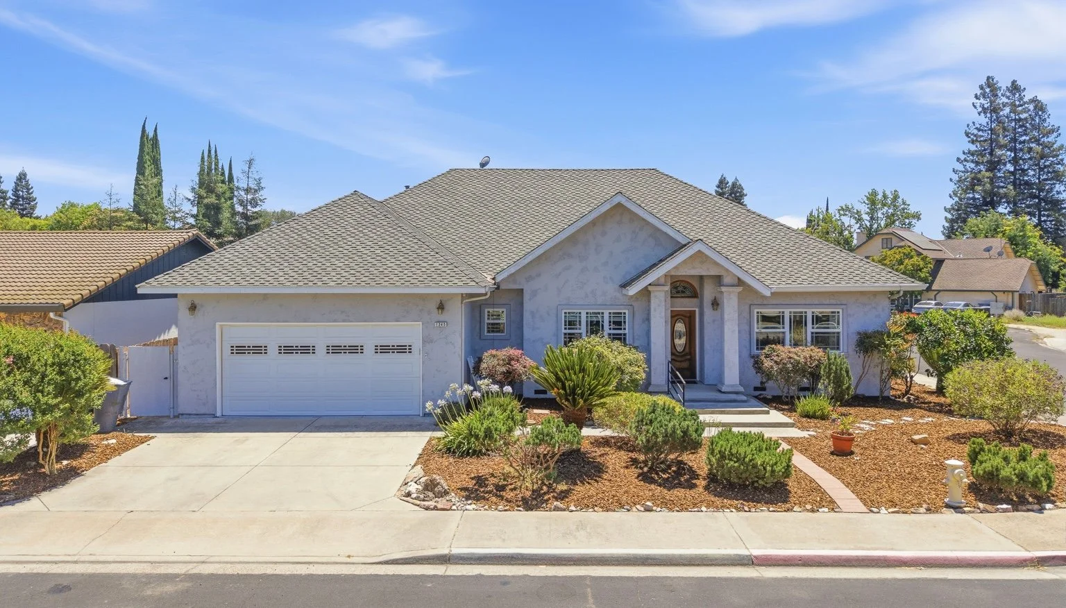 Front exterior of an Oakdale, California home with a two-car garage and landscaped yard.