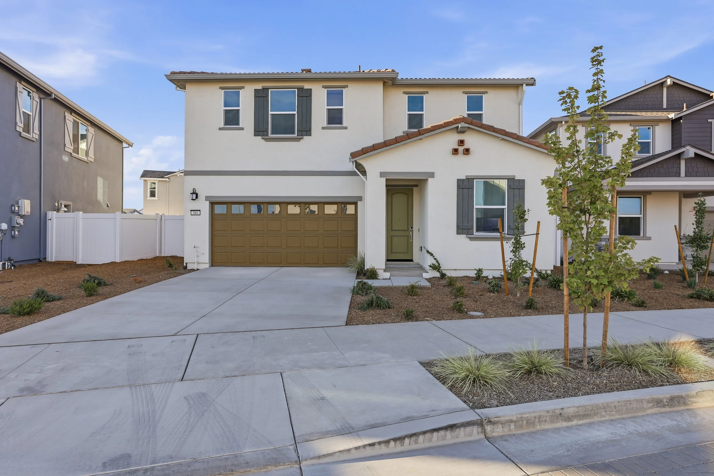 Two-story Ripon home with attached garage, driveway, and new front landscaping.