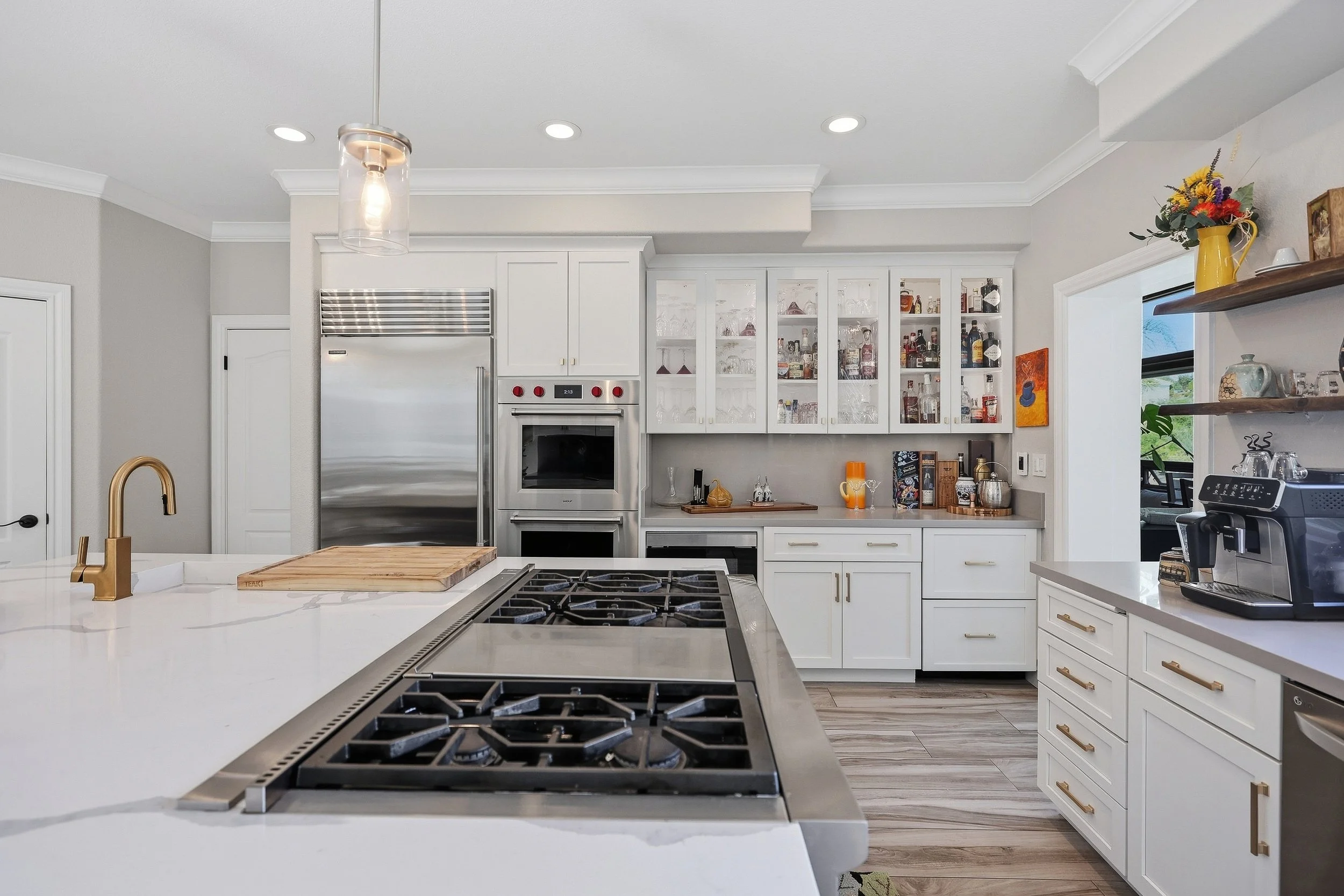 Gas cooktop and white cabinetry in a spacious kitchen.