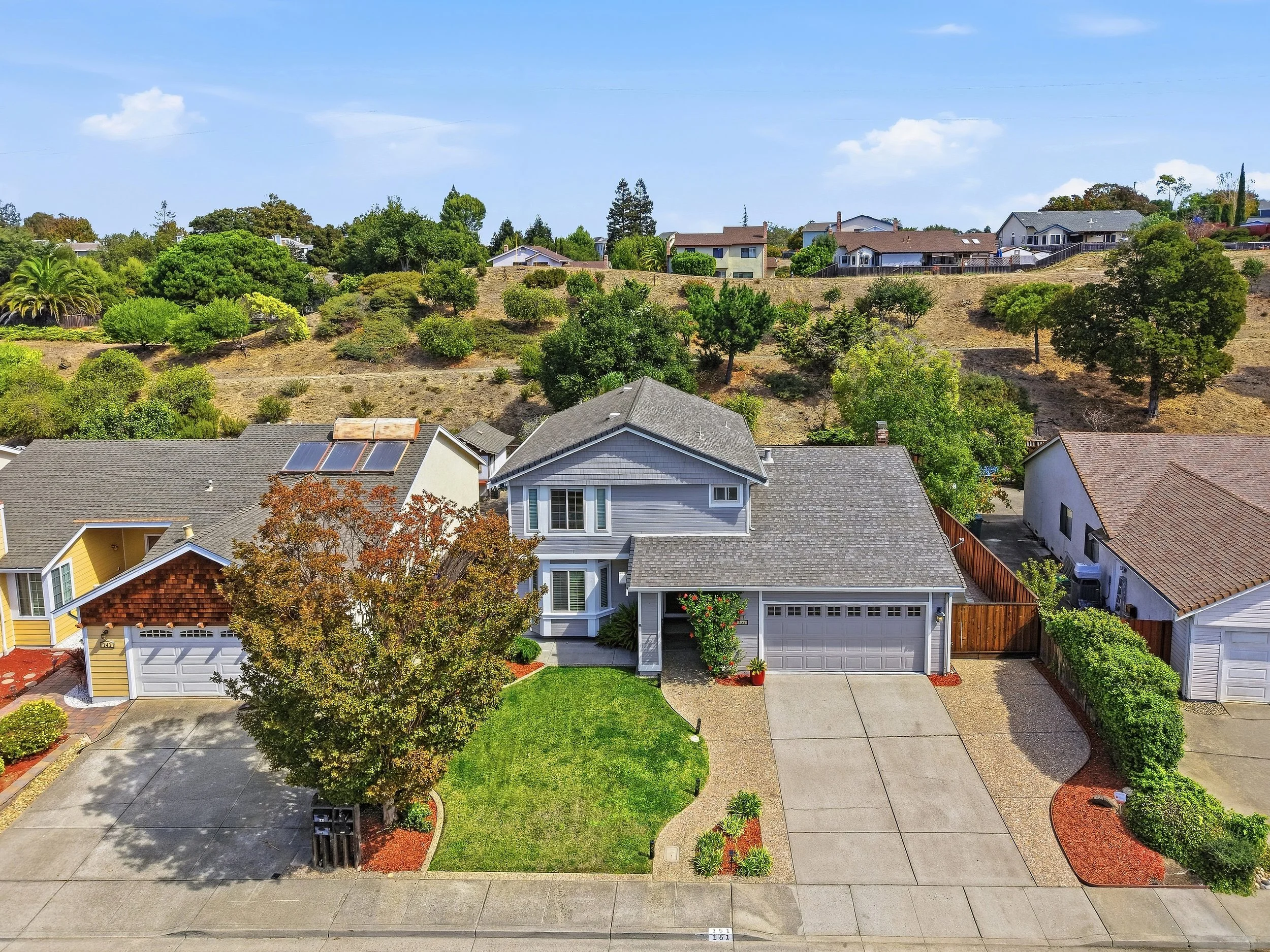 Aerial view of a Hercules home, driveway, and surrounding neighborhood.