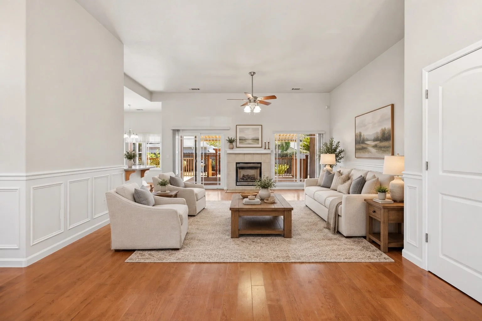 Virtual staging and wainscoting design visualization for an Oakdale living room with neutral furniture and a fireplace.