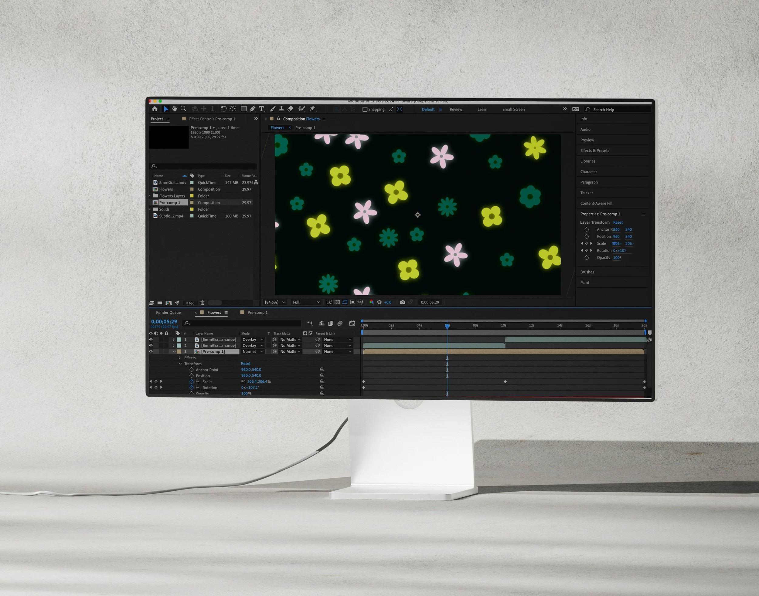 Computer monitor displaying animation software with pink, yellow, teal, and dark blue flower graphics on a black background.
