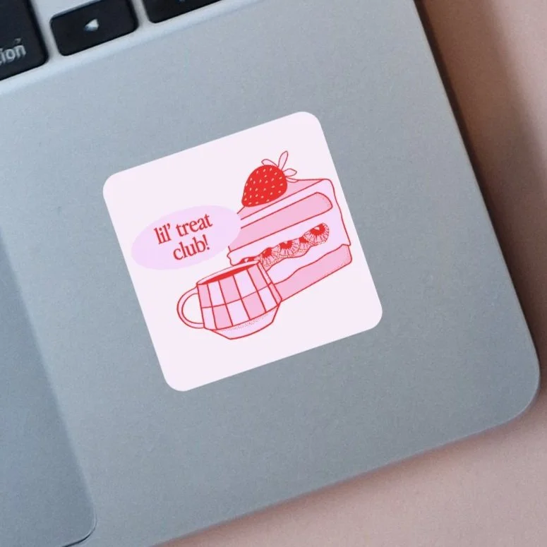 Sticker featuring a slice of cake with a strawberry on top, a mug, and a speech bubble that says 'lil' treat club!'