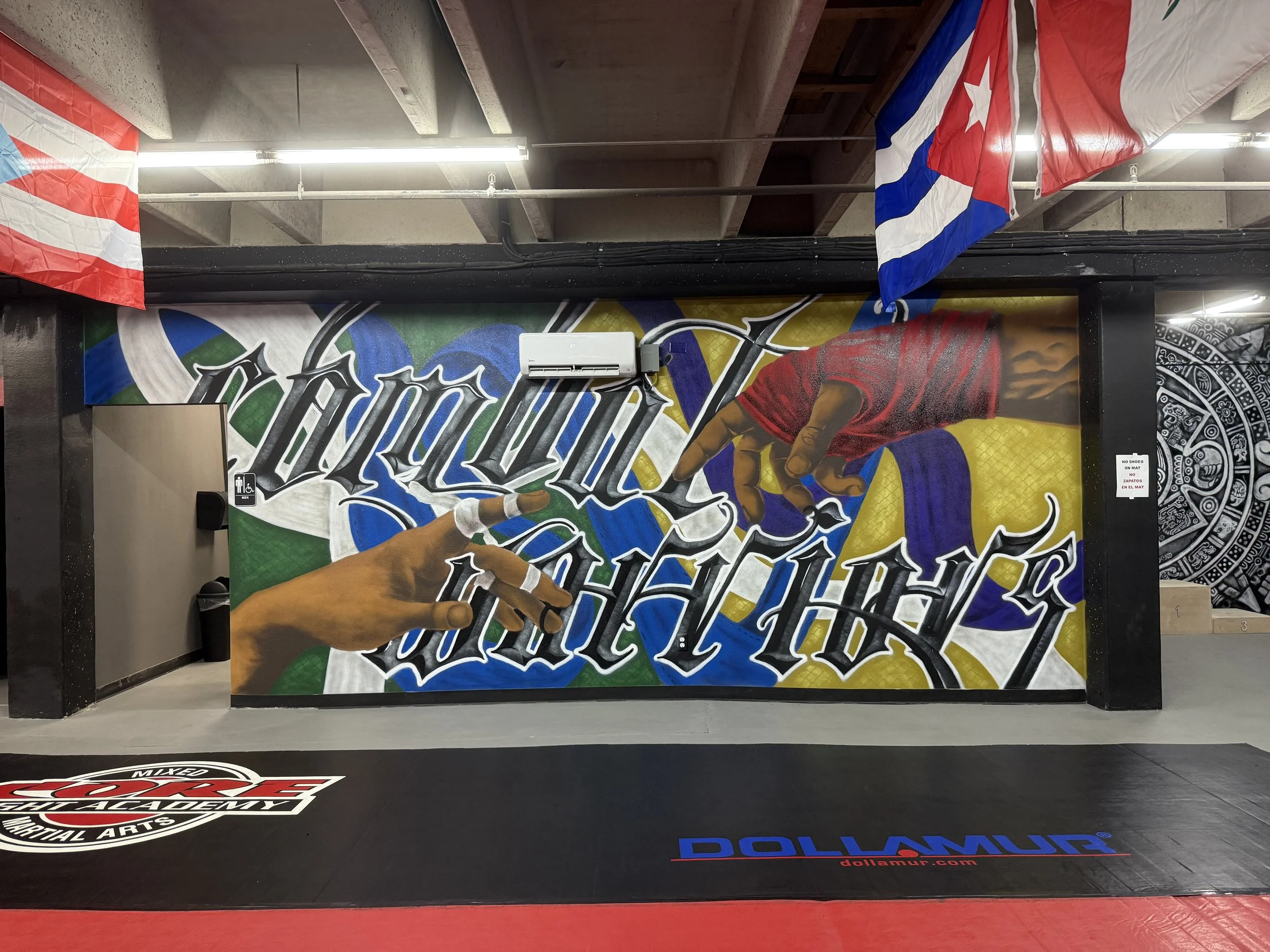 A martial arts interpretation of two hands reaching toward one another. One is wrapped for striking, while the other carries the familiar finger tape of Jiu Jitsu. Belt colors, chain link textures, and beveled Combat Warriors lettering complete a mur