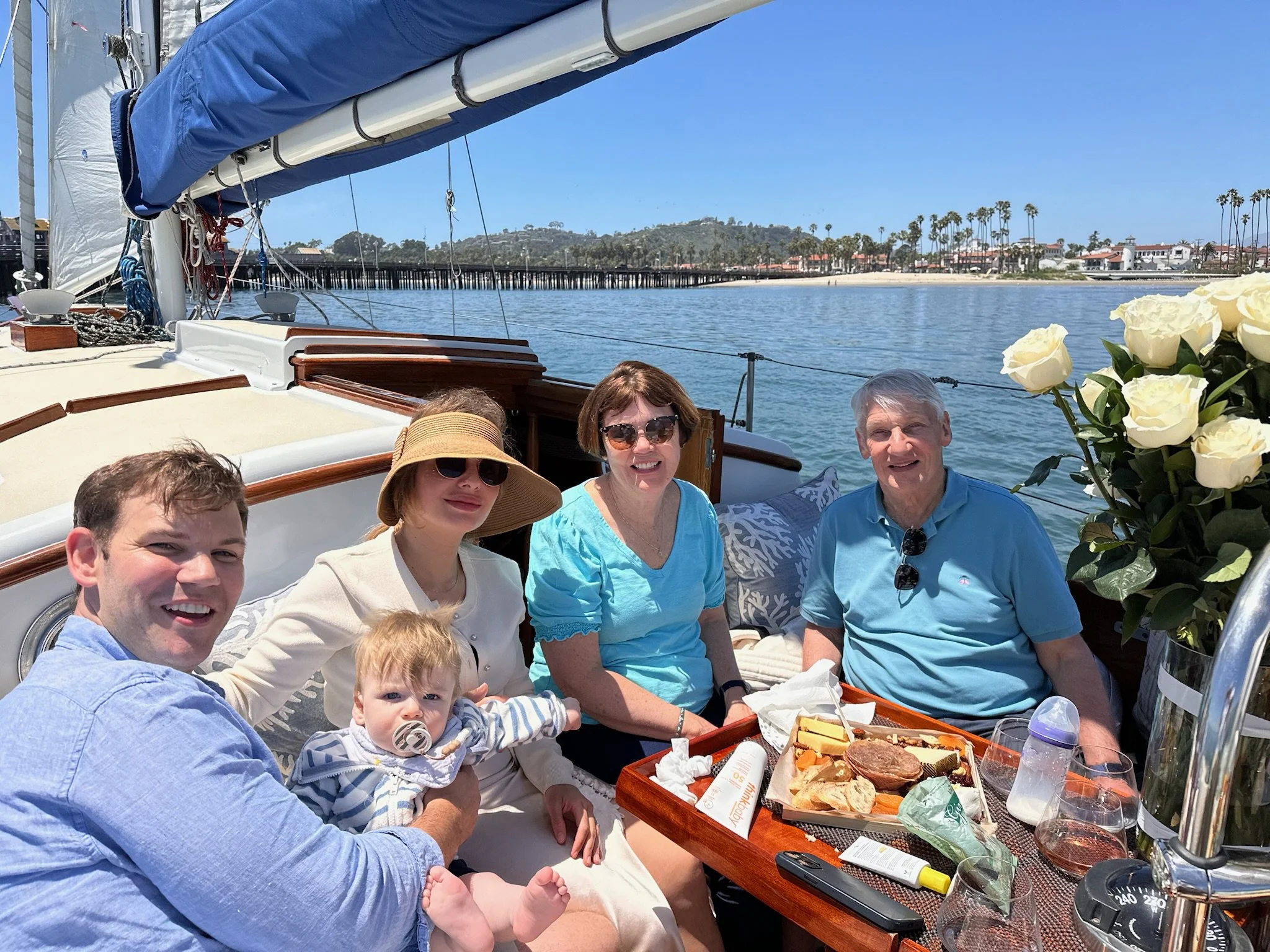 Multigenerational family with a baby enjoying a private harbor cruise aboard Kelpie in Santa Barbara.