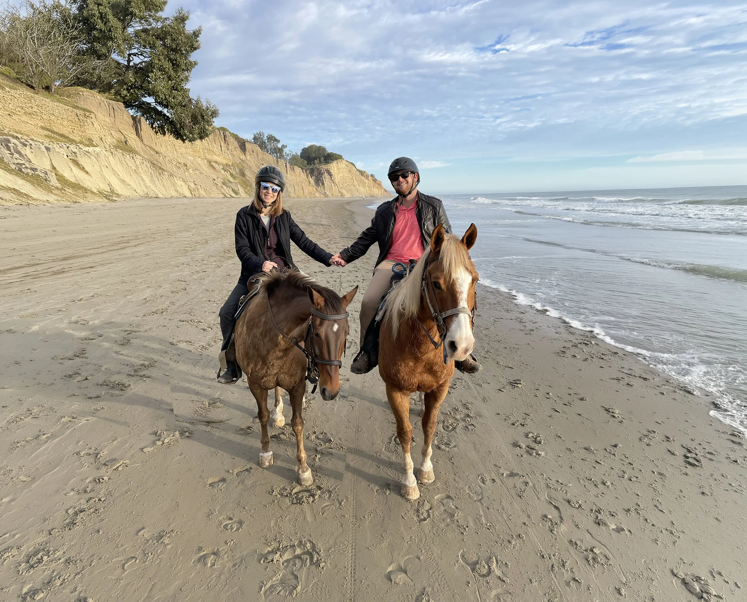 Captain Spencer and Courtney riding horses along the beach in Summerland during the story behind Yacht Kelpie's name.
