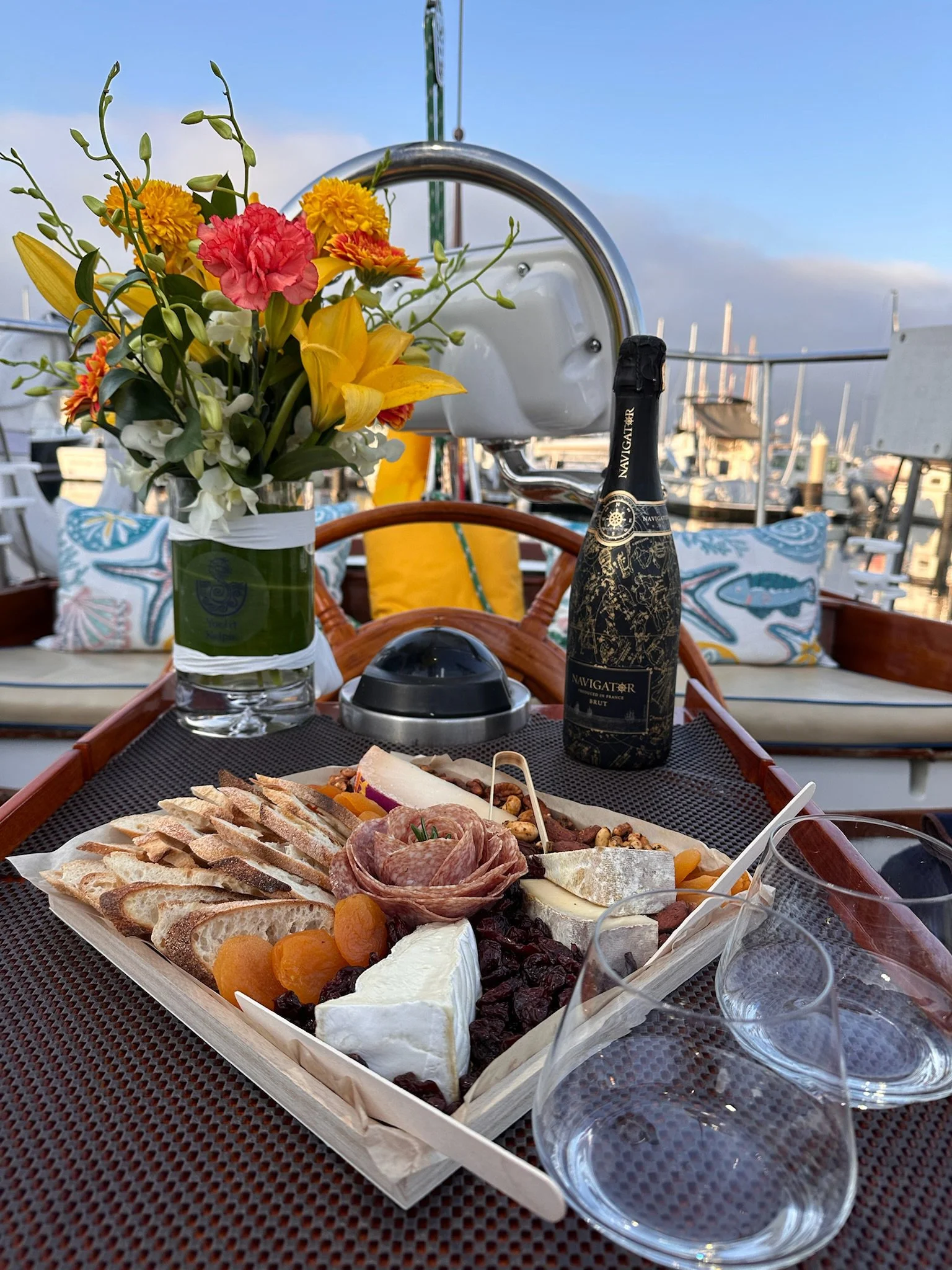 Gourmet picnic platter with artisan cheeses and charcuterie, flowers and sparkling wine aboard Kelpie.