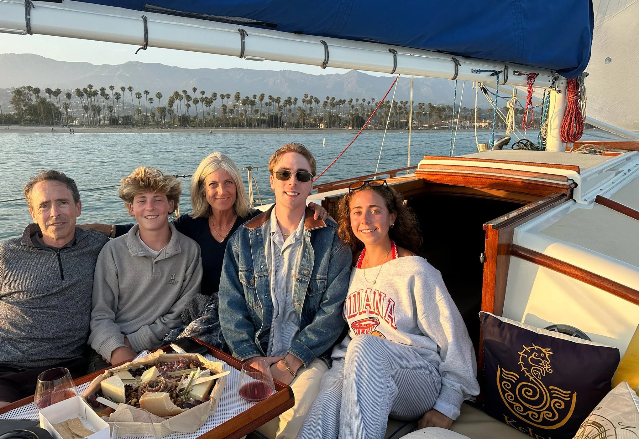 Family and friends gathered aboard Kelpie with a gourmet picnic platter during a private sail along the Santa Barbara waterfront.