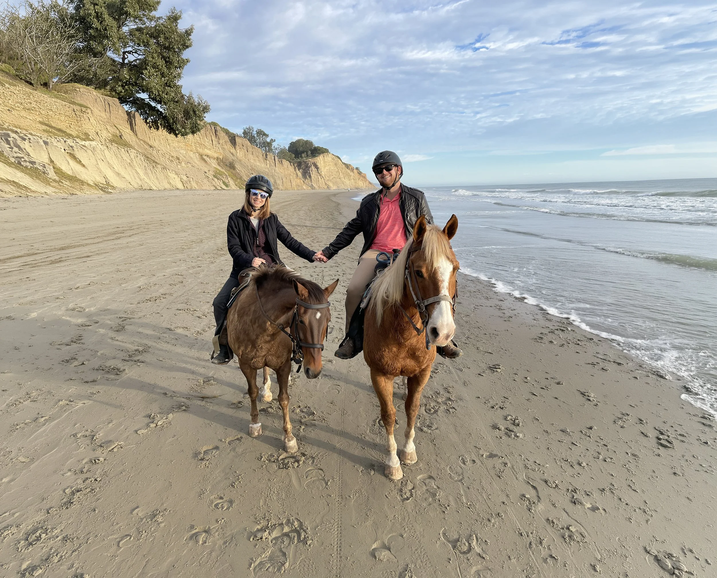 Captain Spencer and Courtney riding horses along the beach in Summerland during the story behind Yacht Kelpie's name.