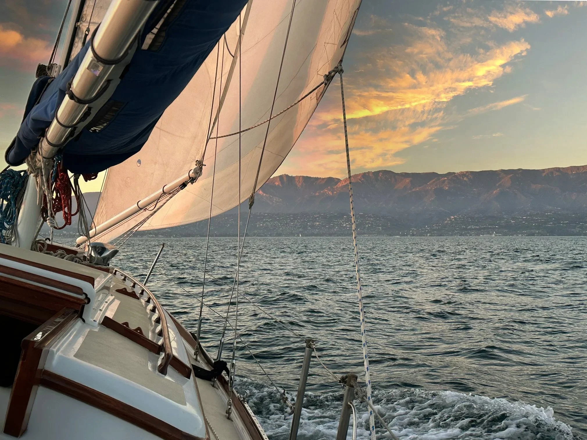 View aboard Kelpie during a sunset sail with the Santa Barbara mountains in the distance.