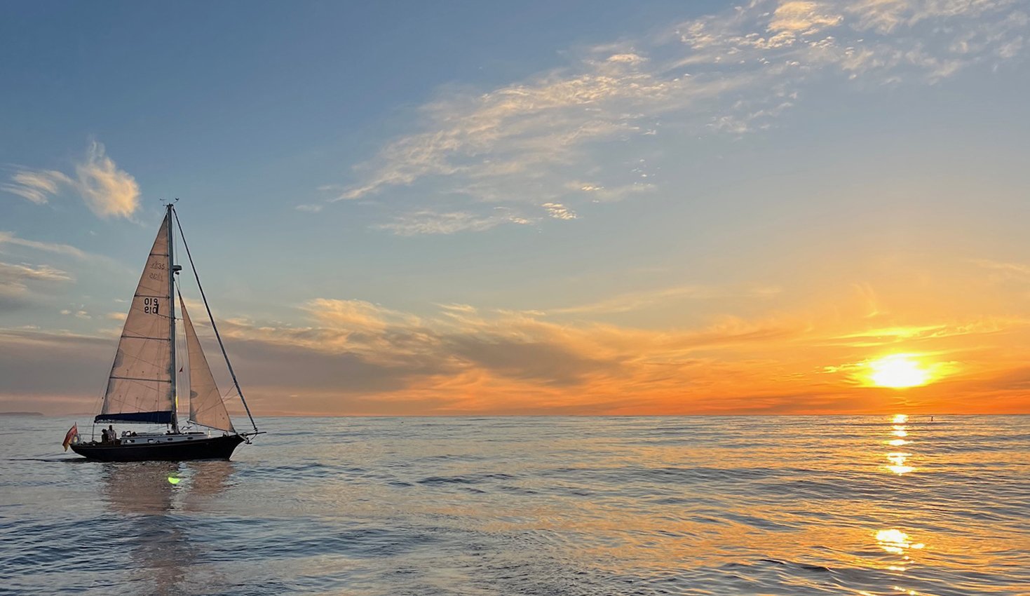 The classic sailing yacht Kelpie sailing at sunset during a private memorial charter in Santa Barbara.