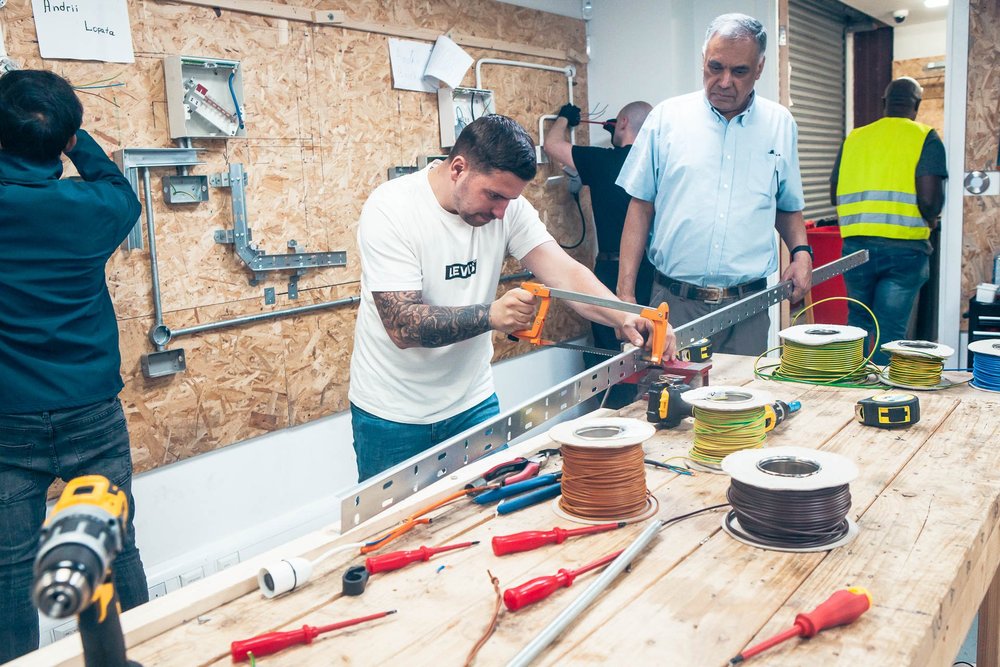 Learners working on a practical installation task in the workshop