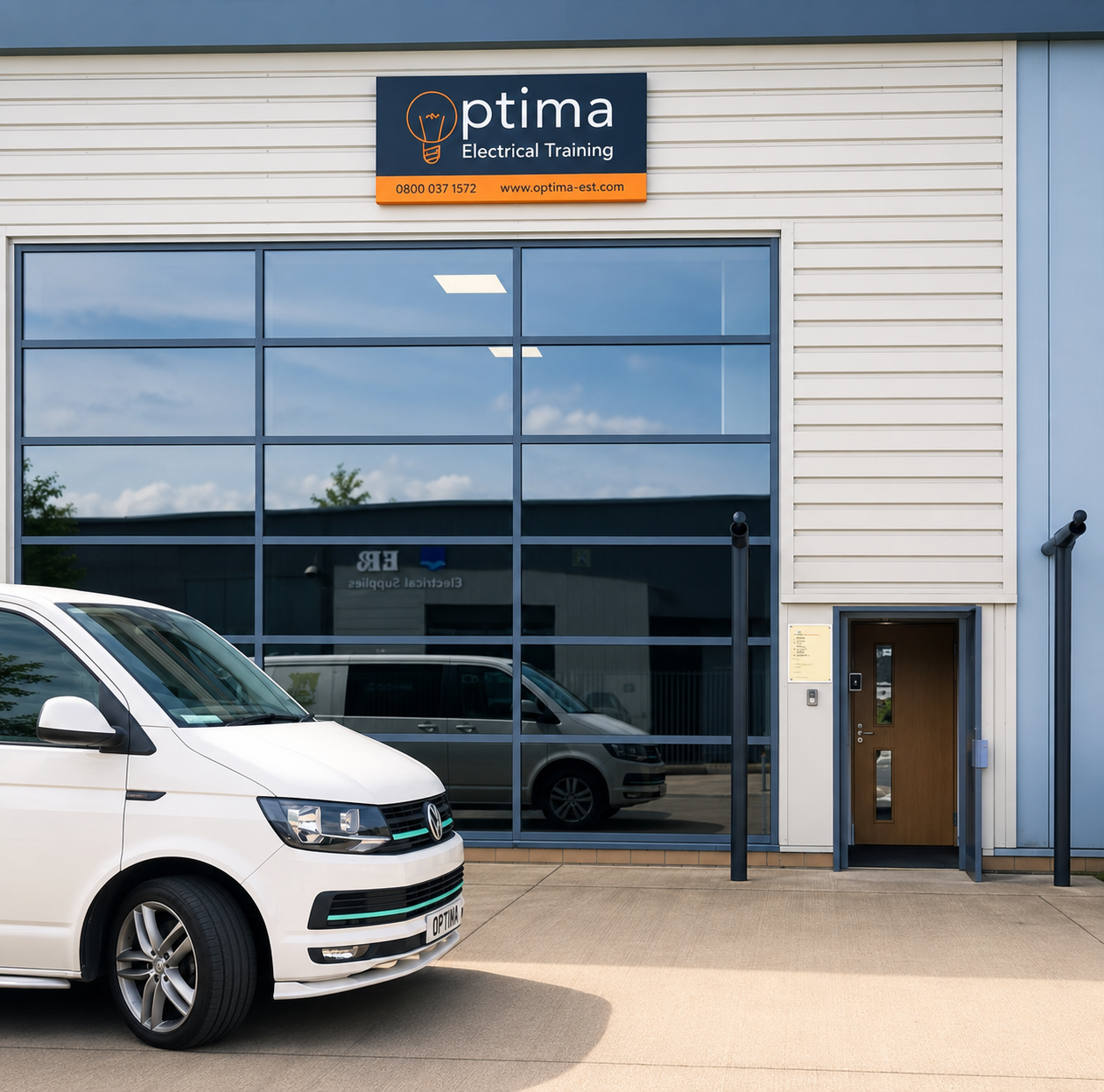 Exterior of a building with a sign for 'Optima Electrical Training' and a white car parked in front.