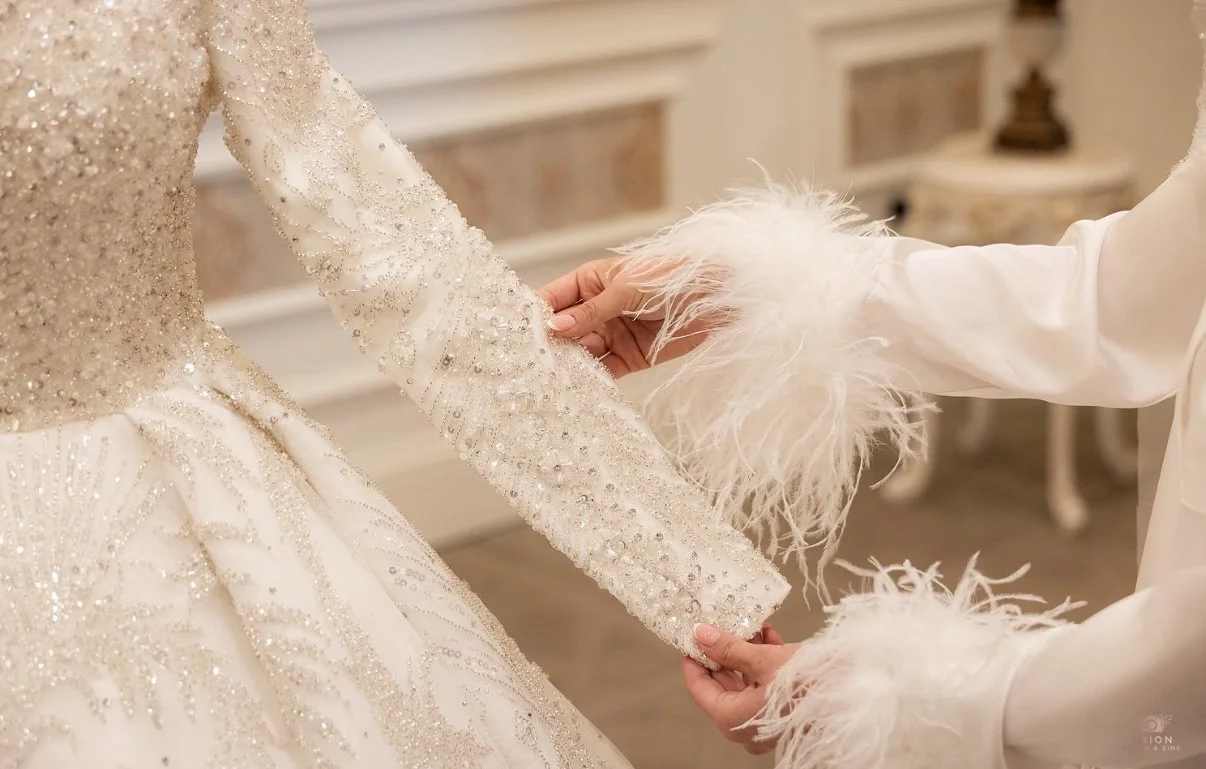 Sewing materials on beige fabric including scissors, measuring tape, thread spool, and bobbin.