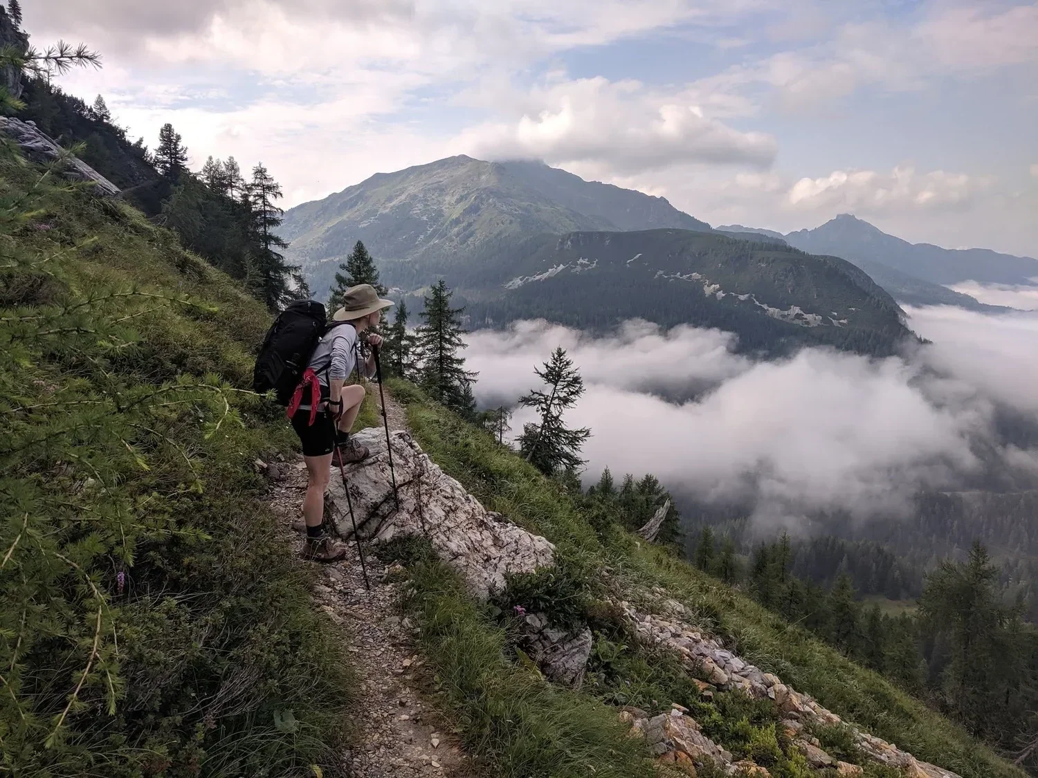 Carrie Dennis, writer, editor, content strategist, and artist pausing to take in the view while hiking the side of a mountain, while wearing athletic attire