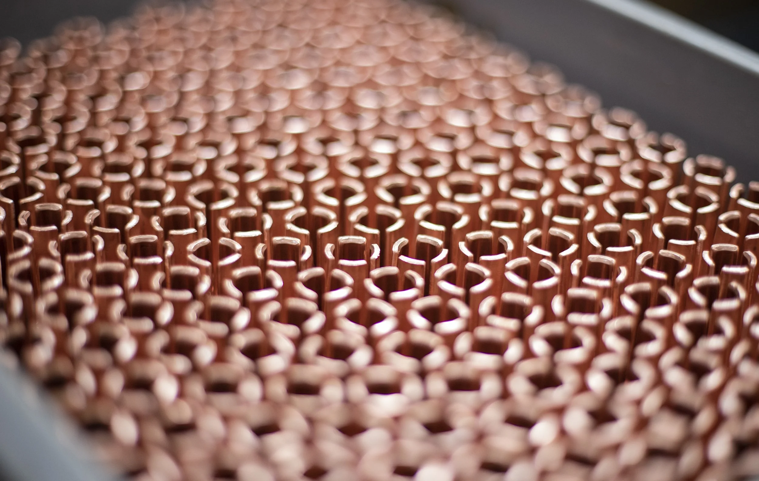 Close-up of metal components with copper color arranged in a grid pattern